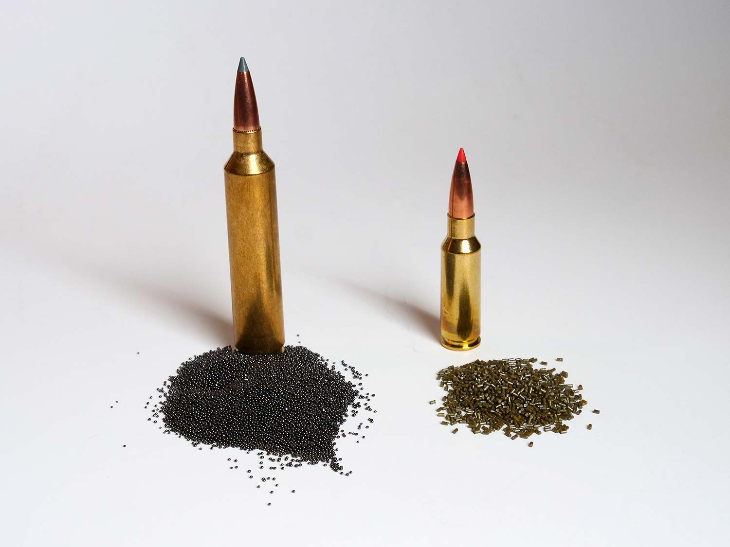 Two rifle bullets and their gun powder load poured out next two them.