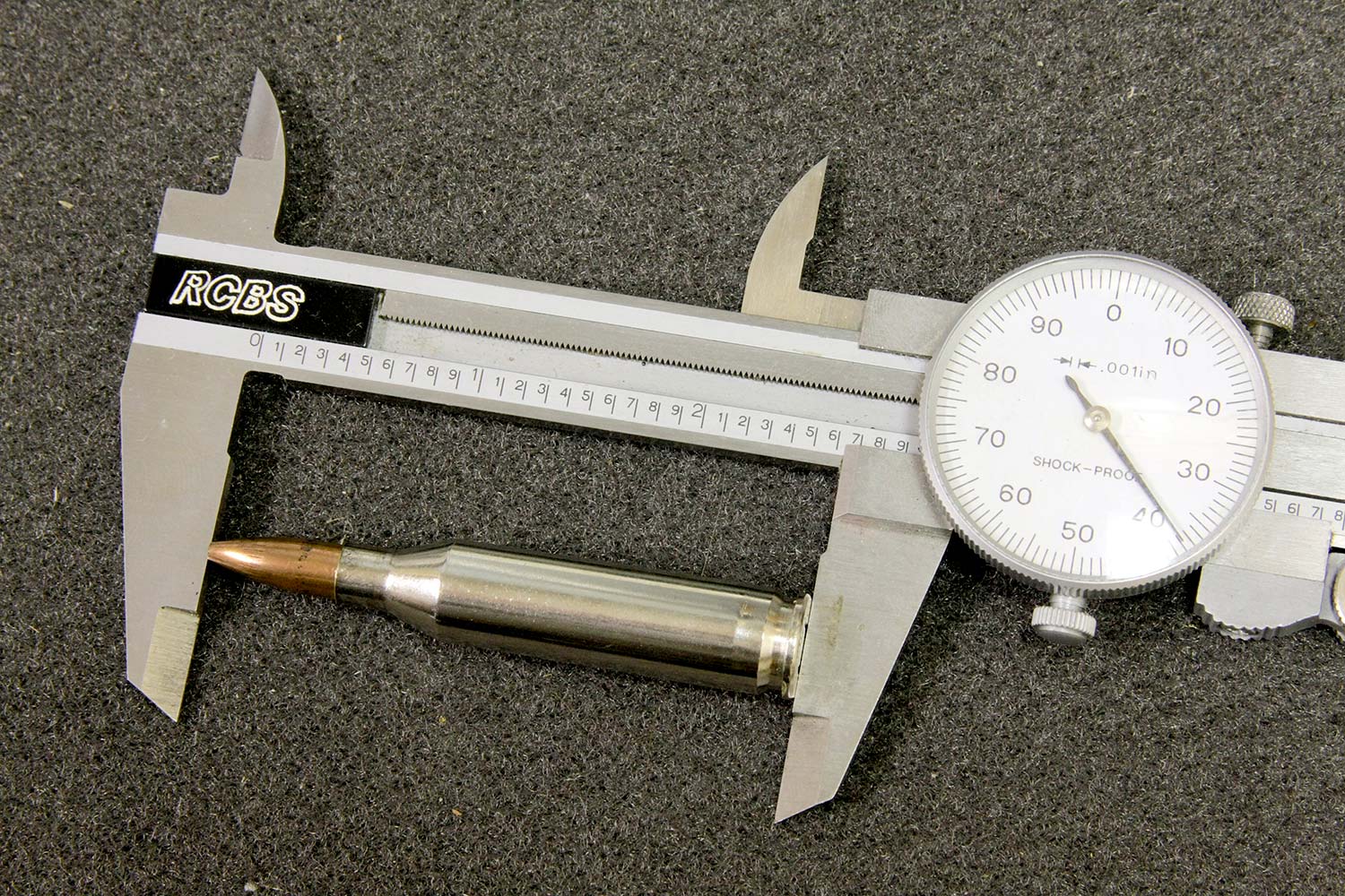 A small mechanical caliper used for rifle ammunition measurements for length and width.