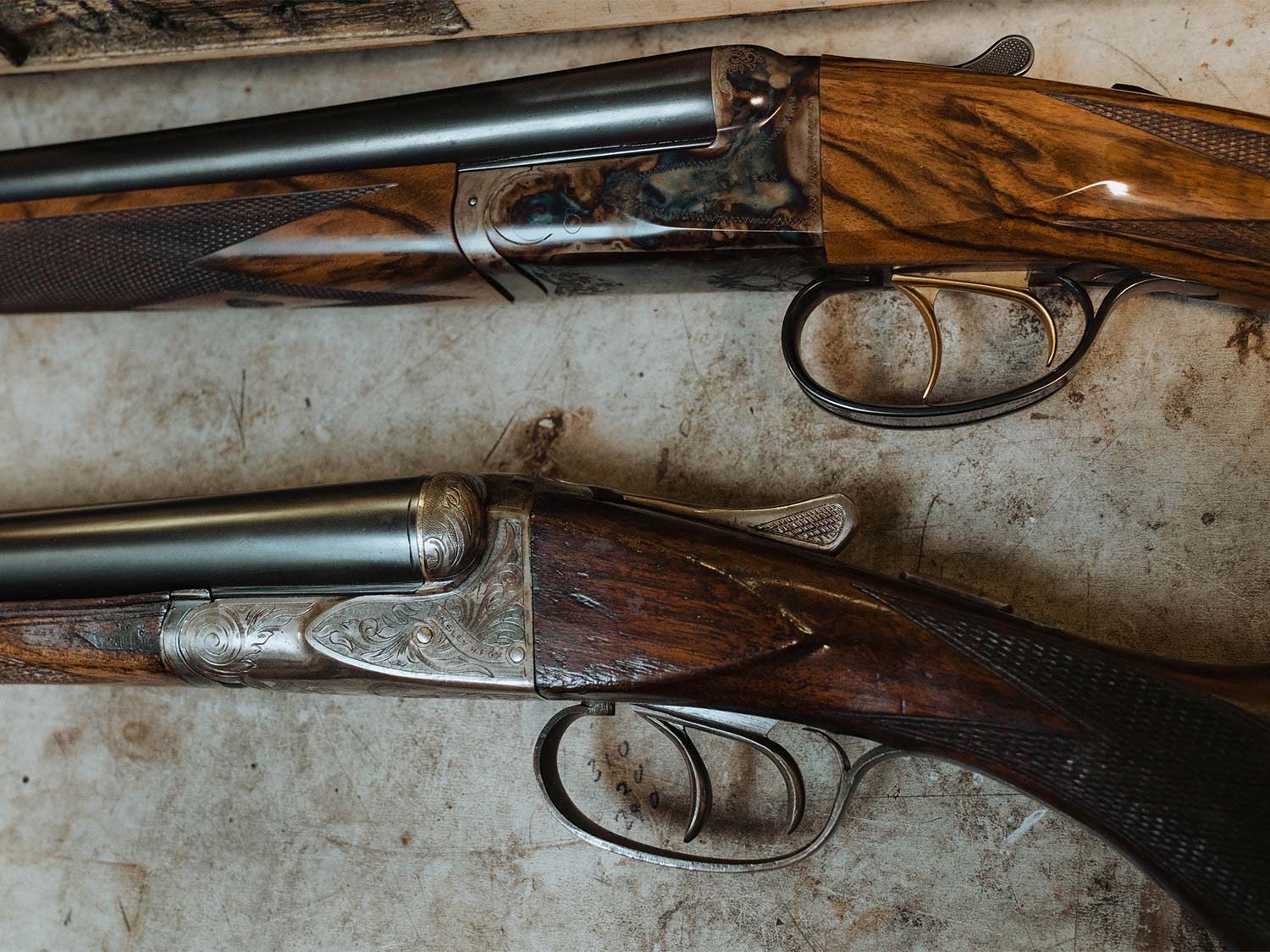Two side-by-side-shotguns with great woodwork and custom engraving.