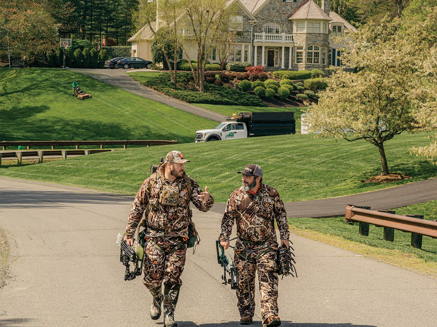 Two hunters in full camo walk down the street in the middle of Virginia suburbs.