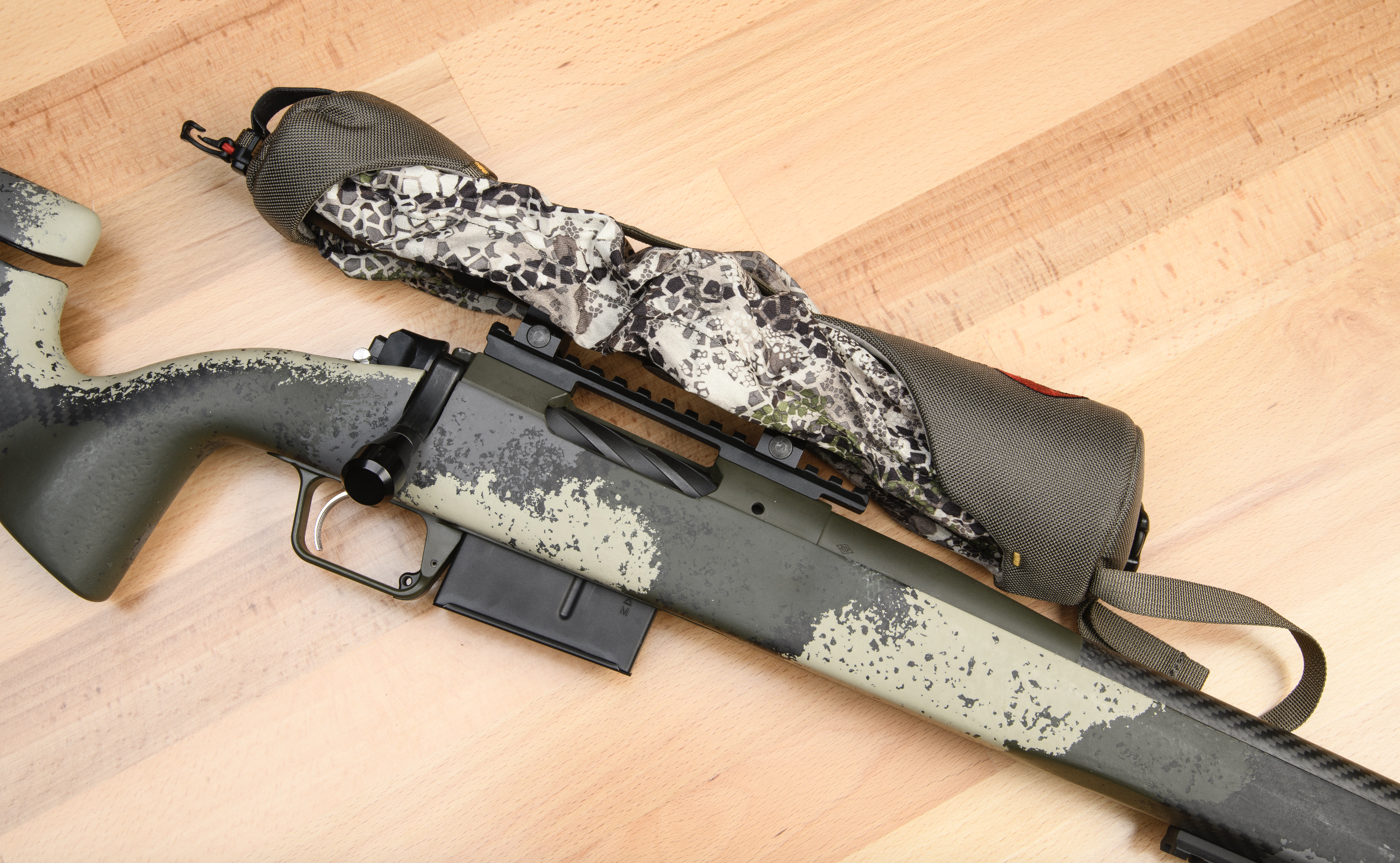 A scope cover in Badlands camo cinched over the scope on the Springfield Waypoint camo-stocked bolt-action hunting rifle.
