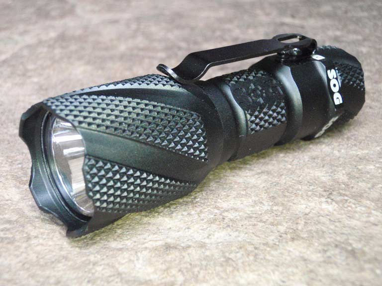 A tactical flashlight on a table.