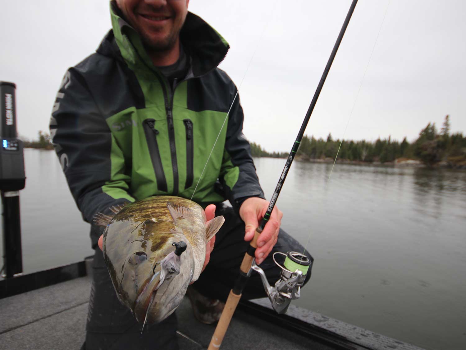 An angler holds up a bass.