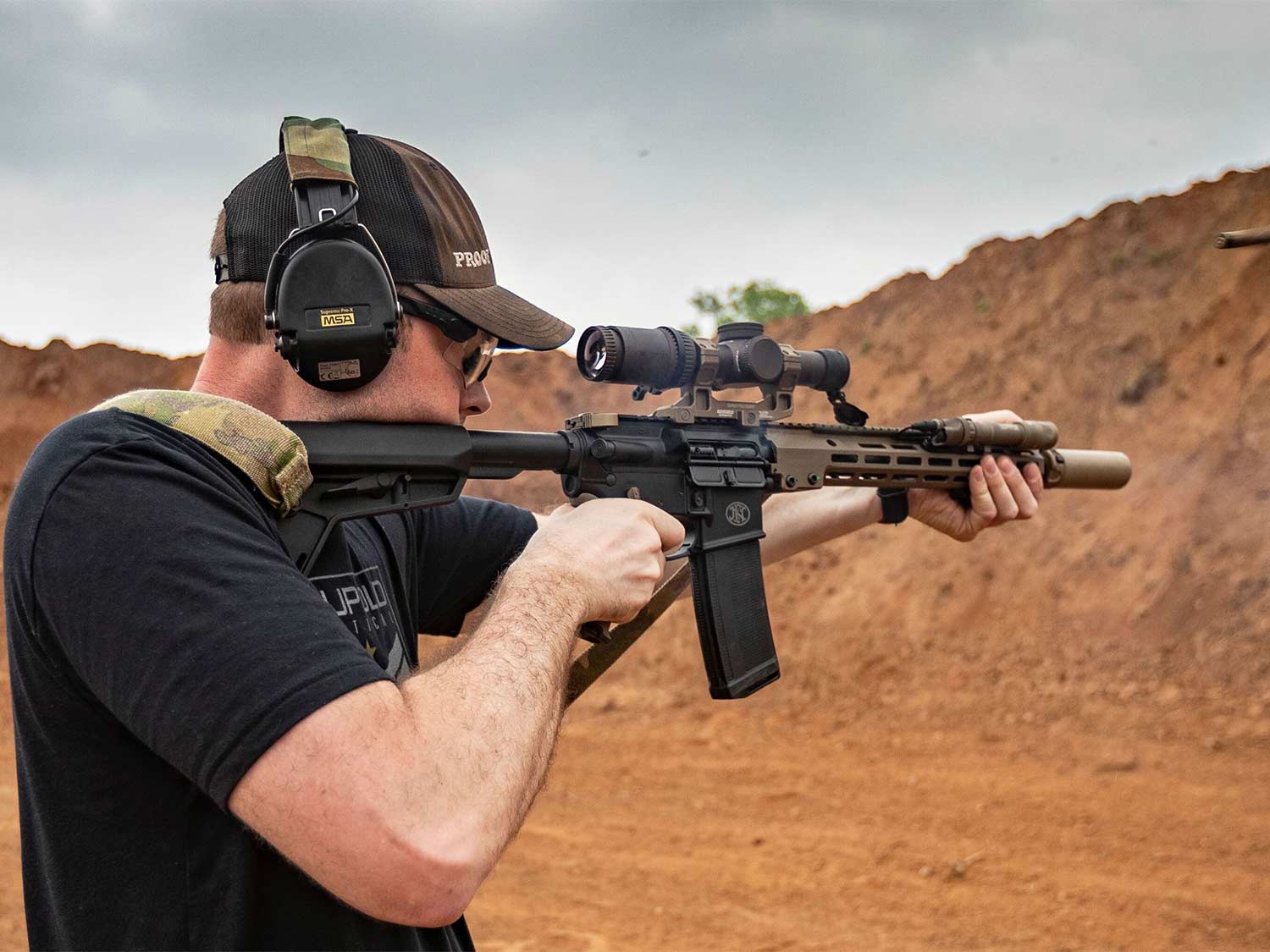 A man aims a rifle at a shooting range.