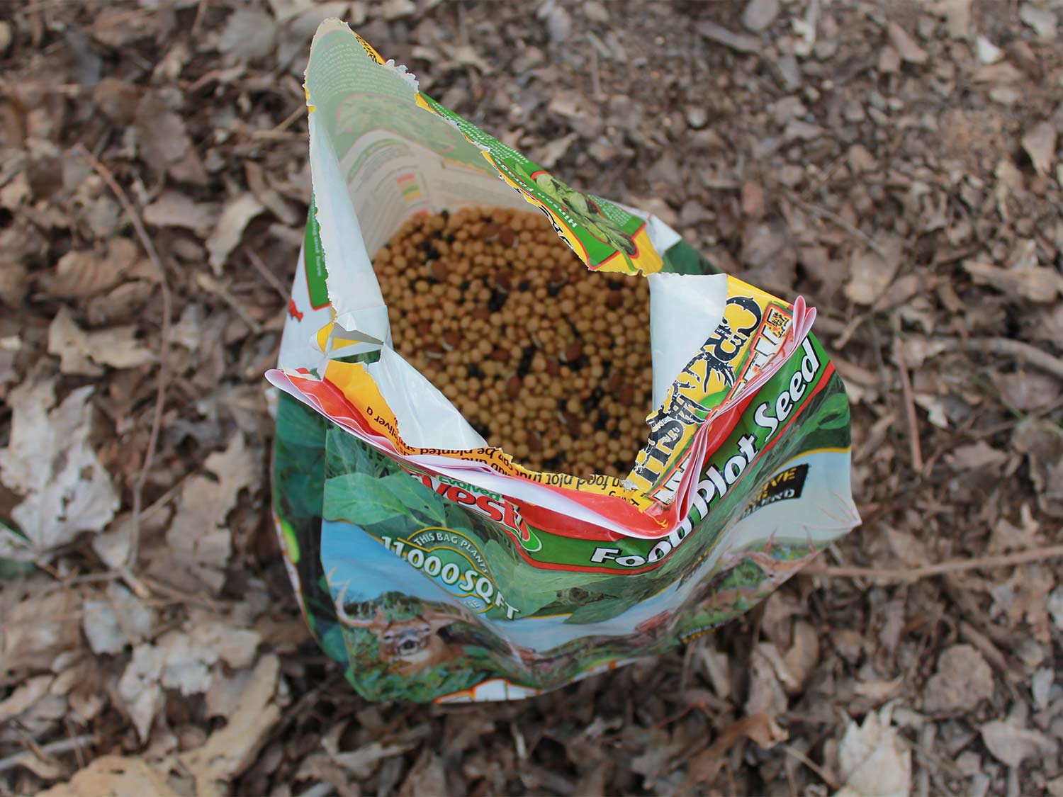 A bag of food plot seed on the ground.
