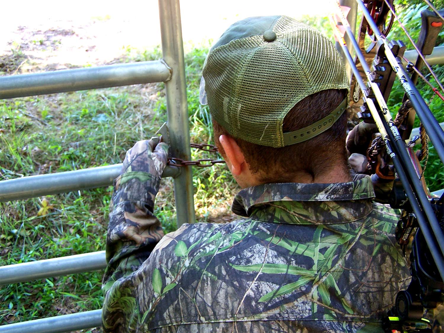 A hunter opens a chain link to open a gate.