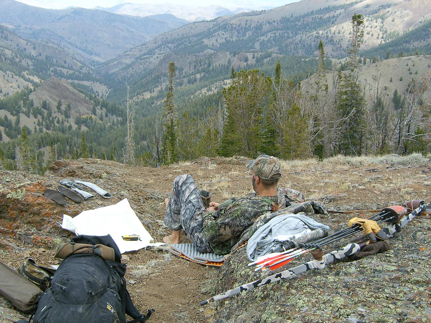A hunter relaxes at a camp site.