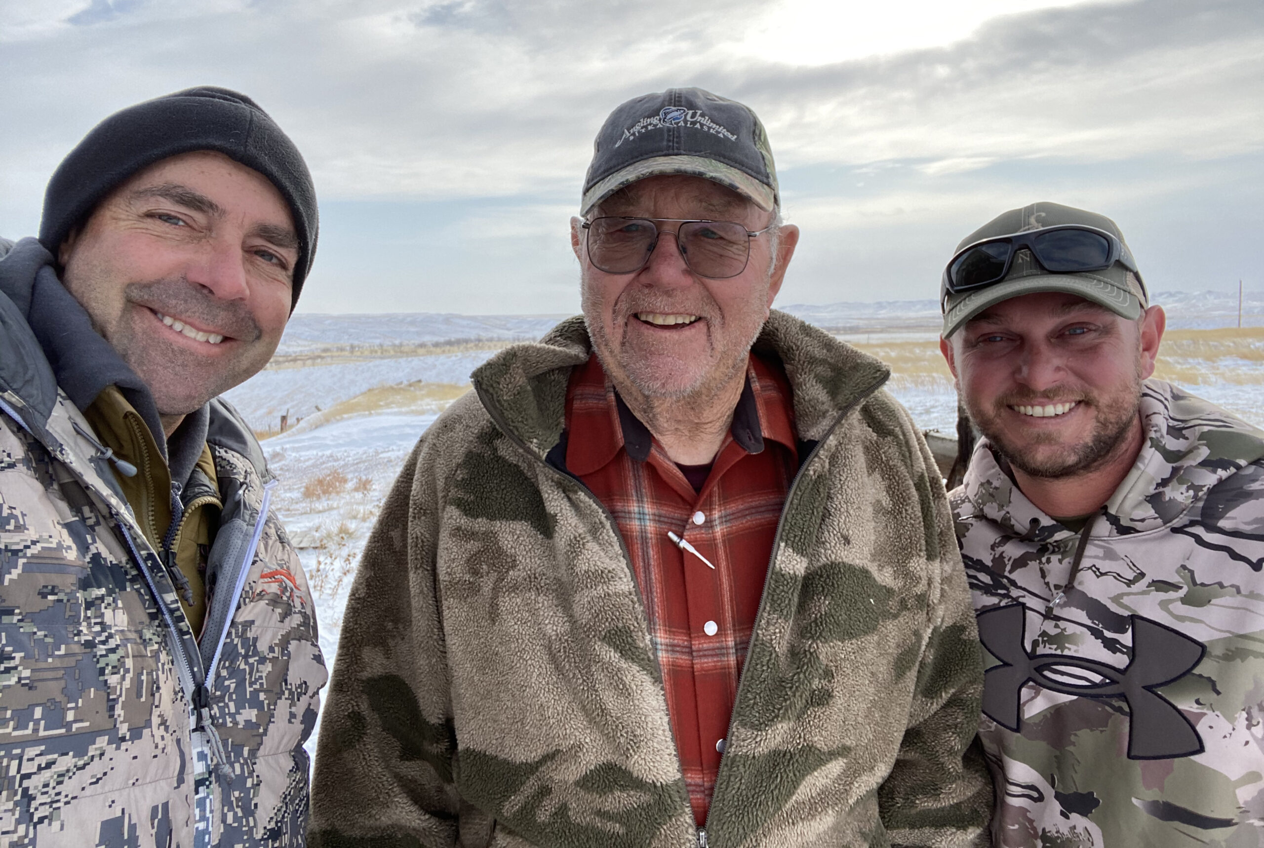 Three Western deer hunters in three types of camo snap a selfie in front of the snowy Montana prairie.