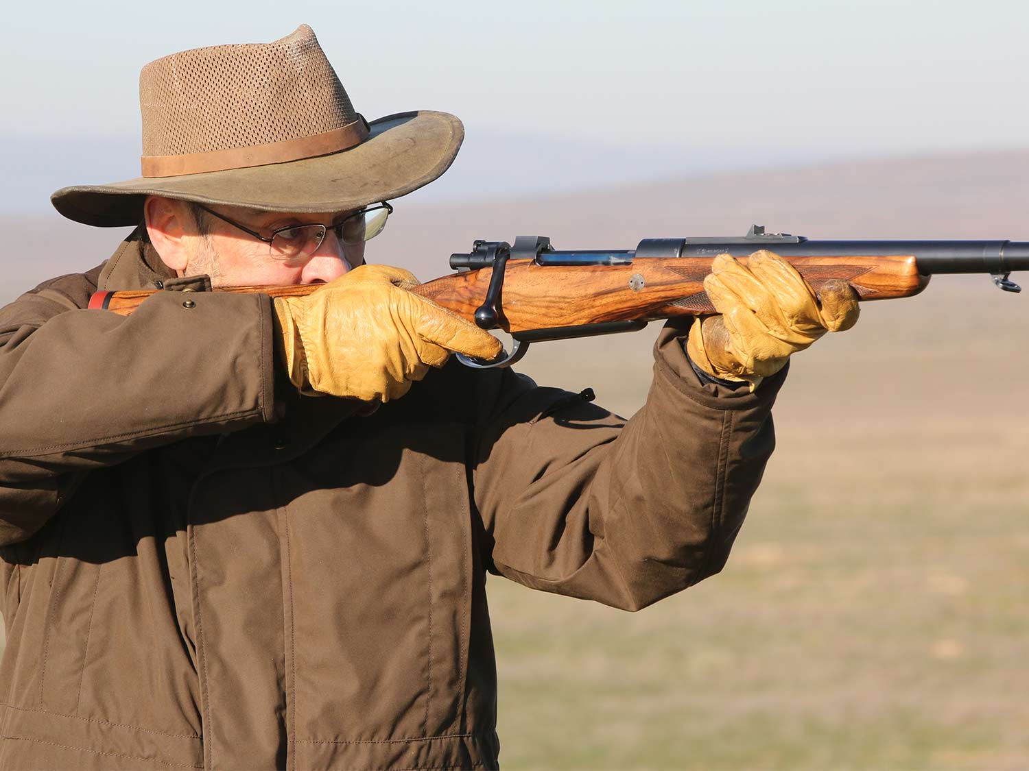 A hunter aiming a CRF Mauser rifle.