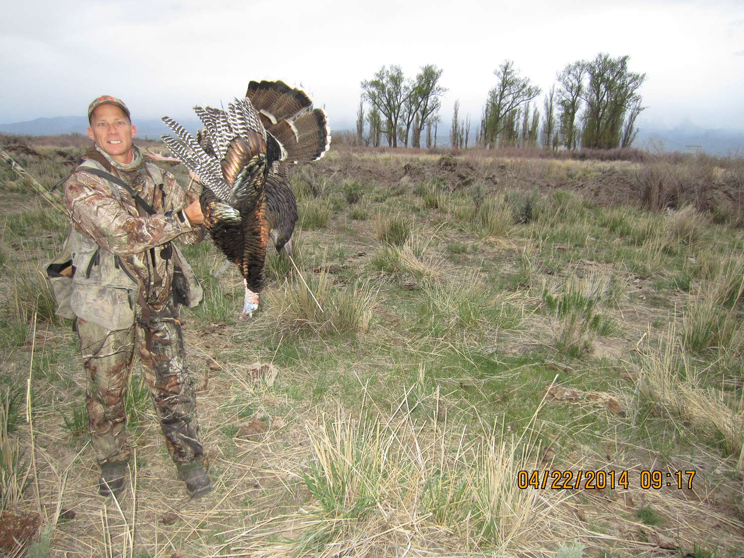 A hunter holds up a turkey.