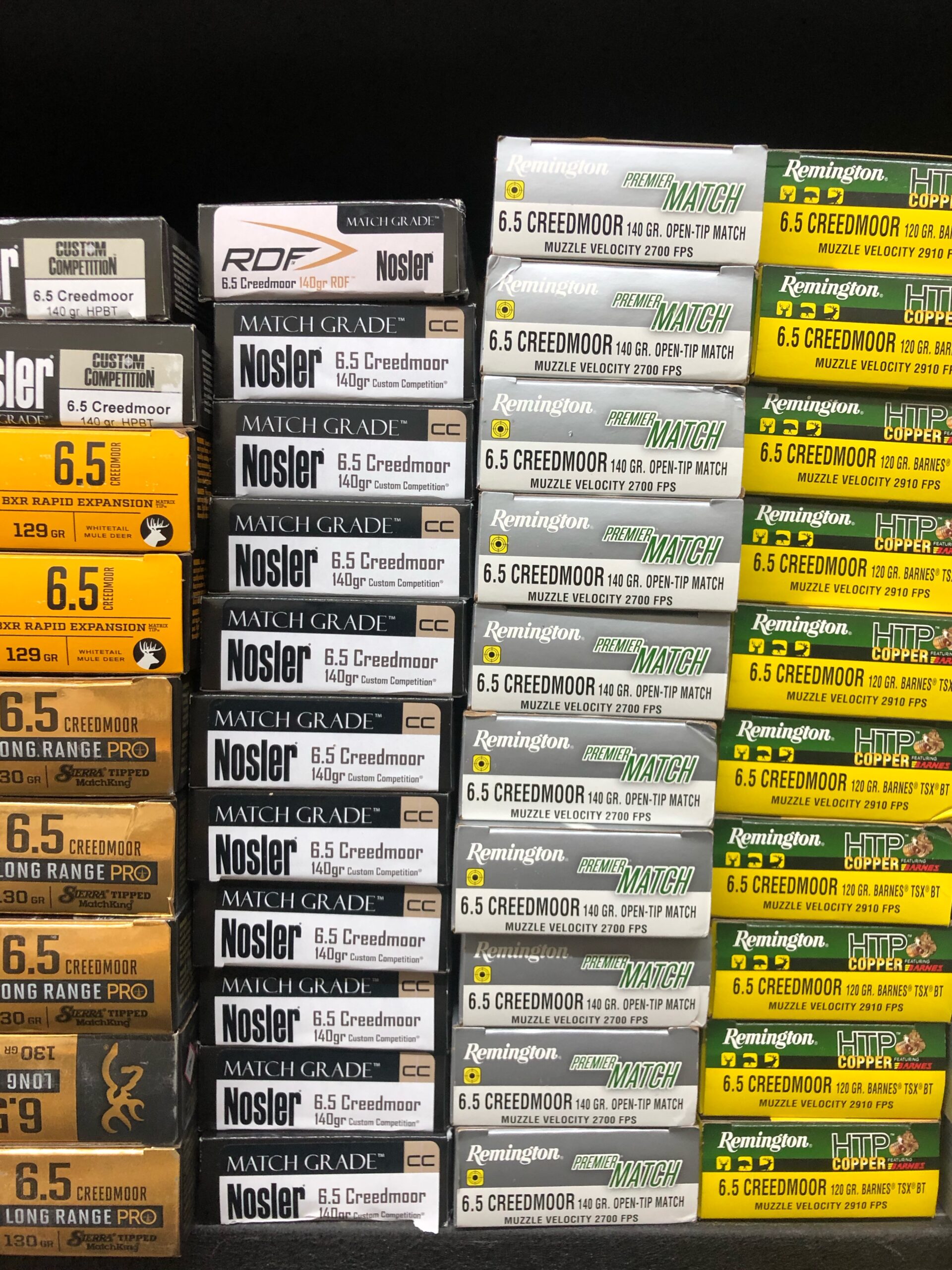 A stockpile of 6.5 Creedmoor hunting ammunition in a variety of brands.