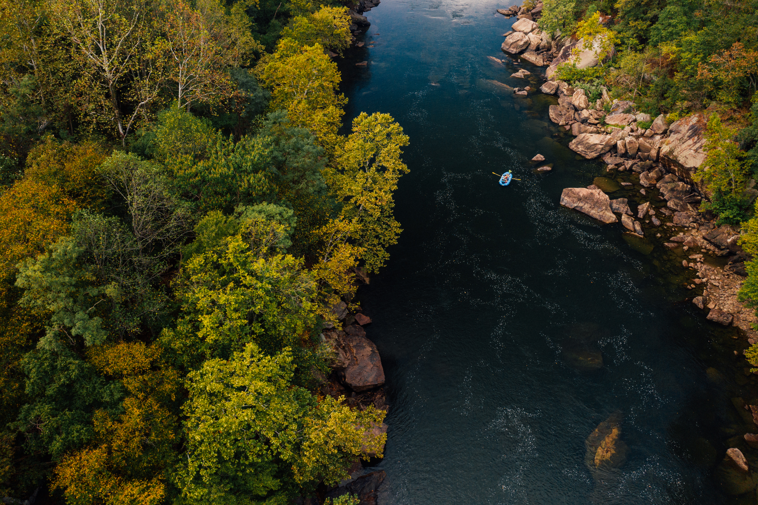 A drone shot of a raft on the New River Gorge National Park and Preserve.