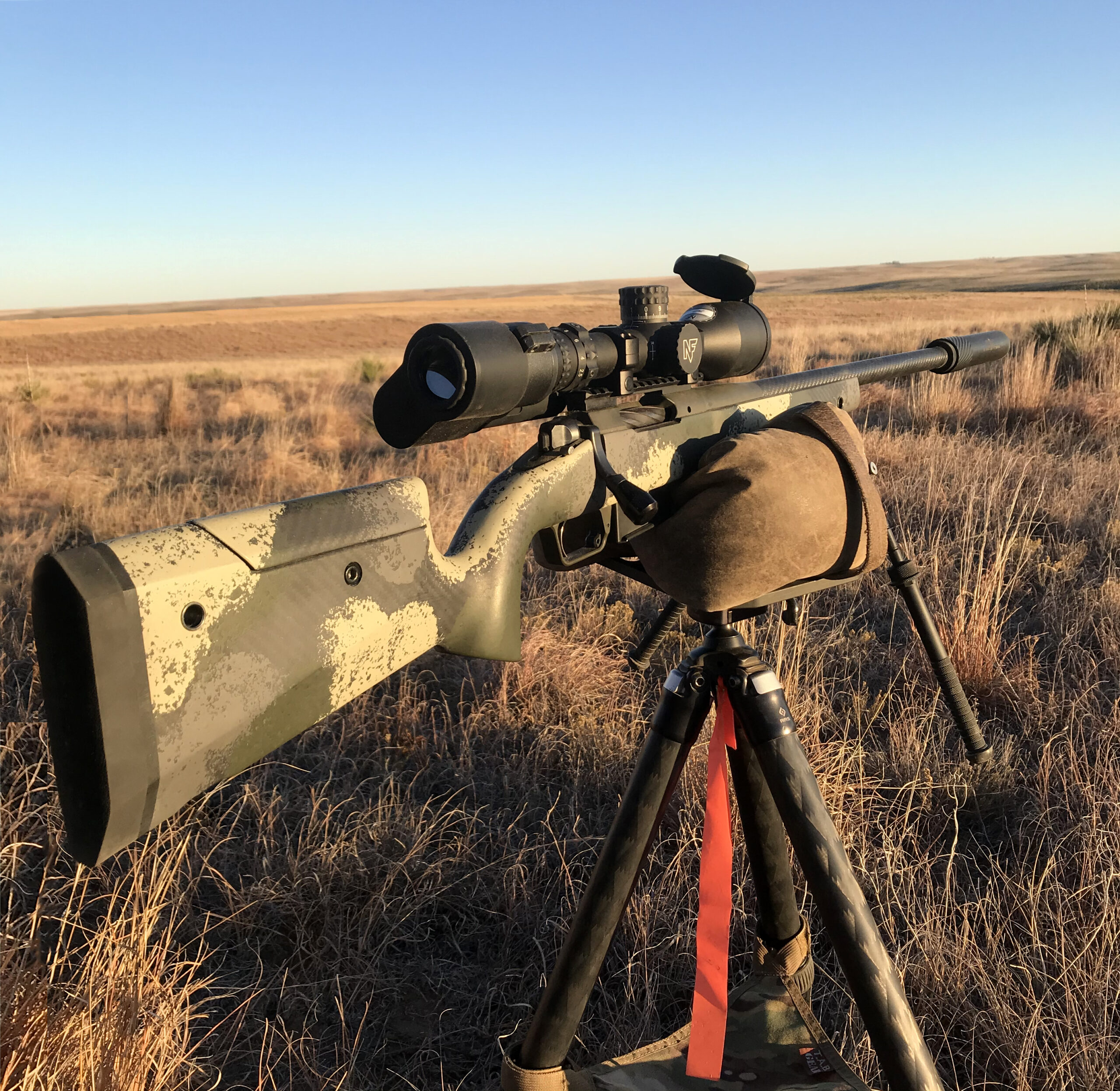 A camo-finished Springfield Waypoint 2020 hunting rifle resting on a tripod in the field.