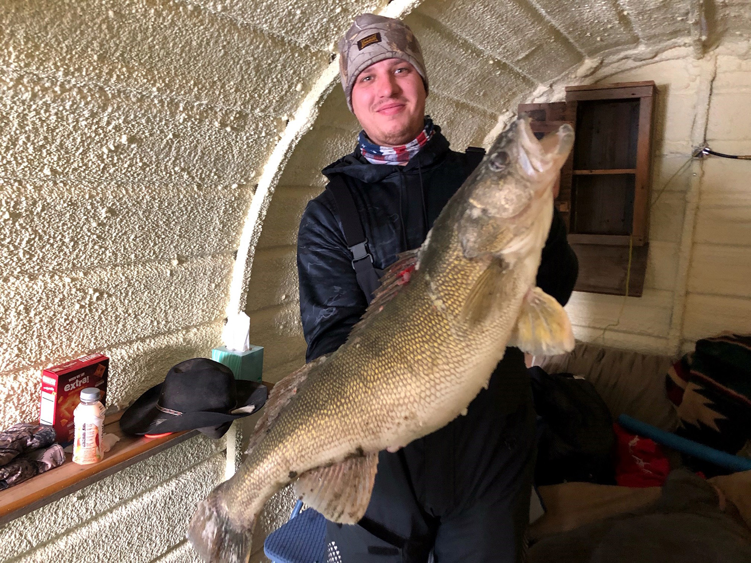 An angler holds up a large walleye.