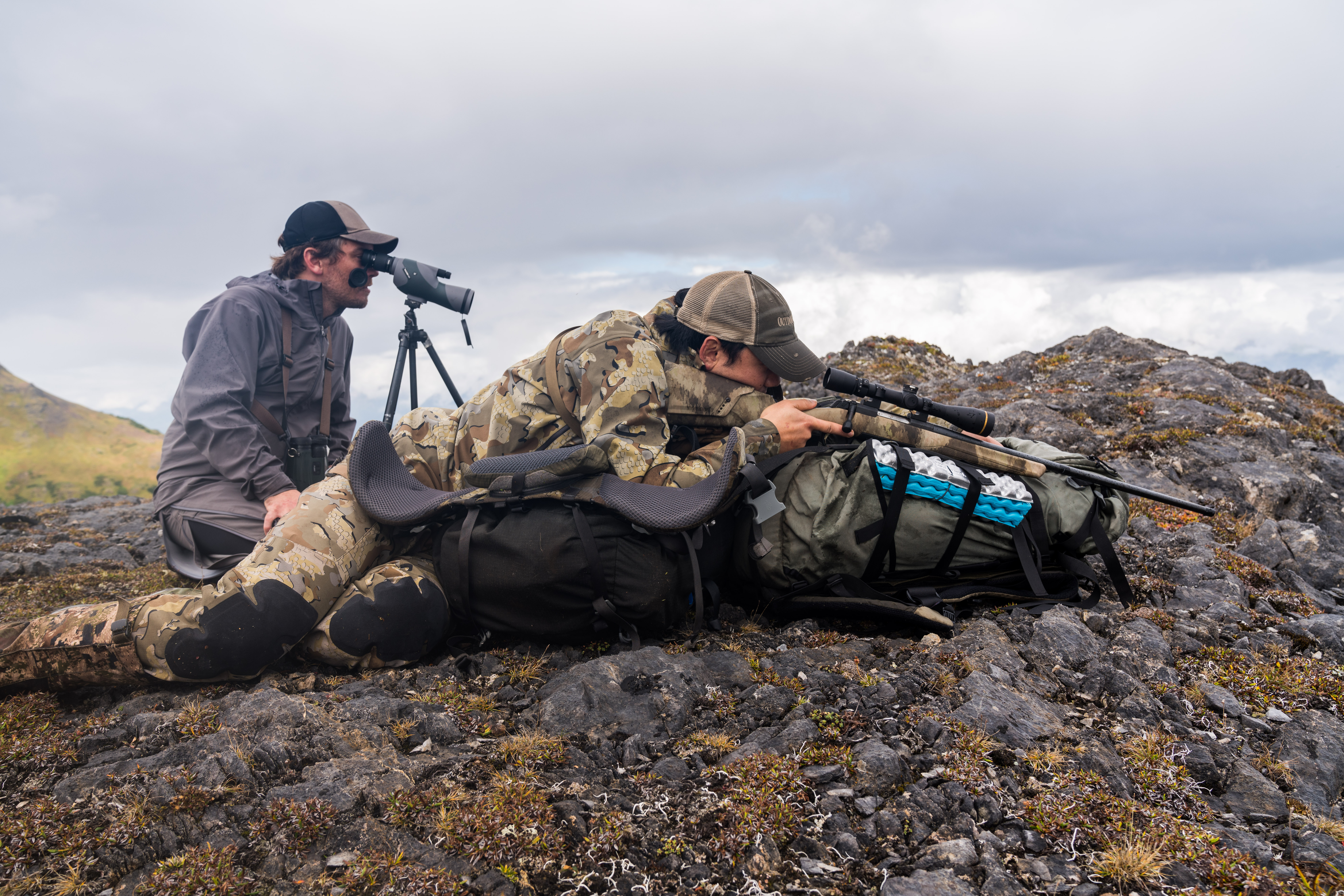 A hunter and a spotter, set up for a mountain goat hunt.