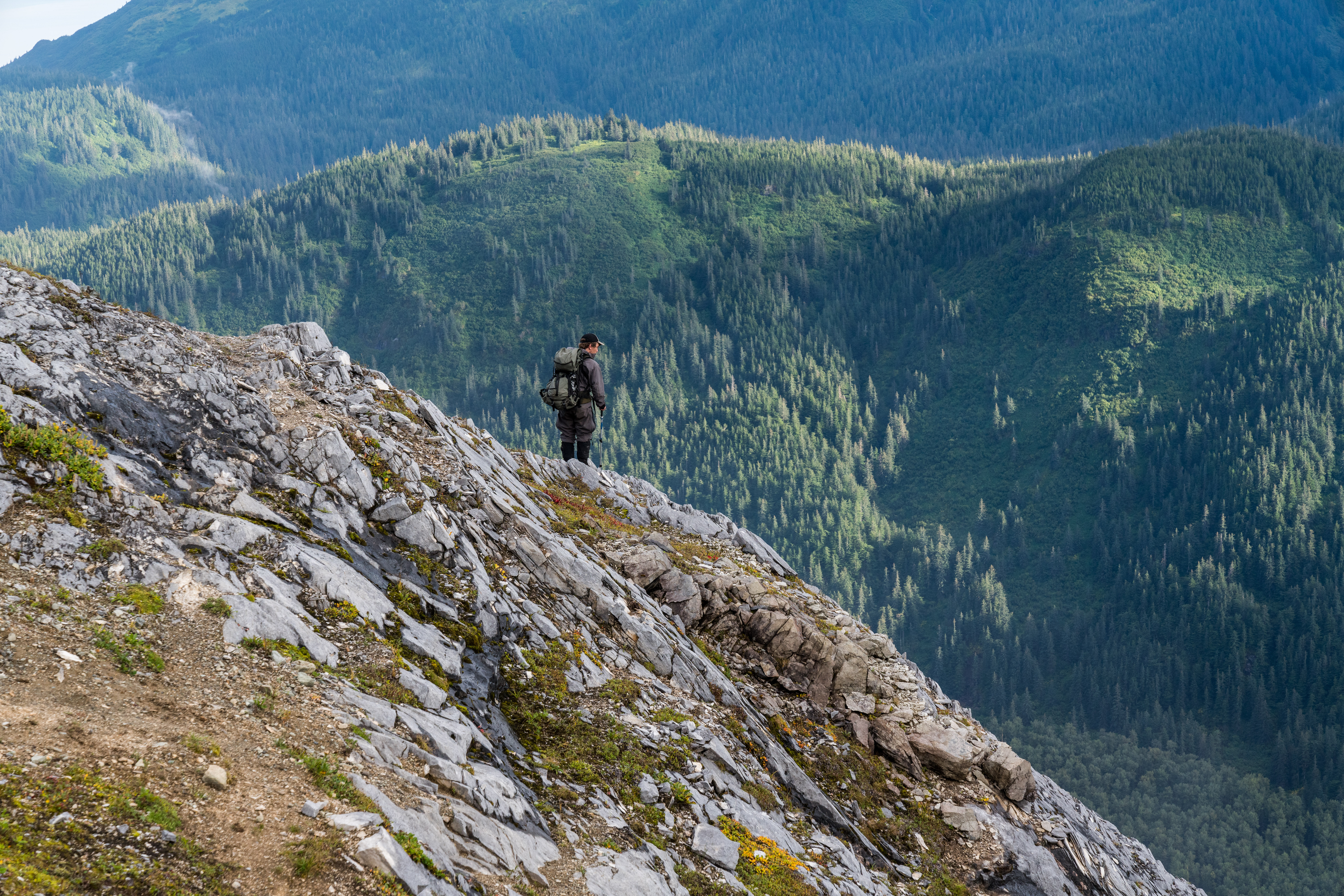 A mountain goat hunter checks a ridge