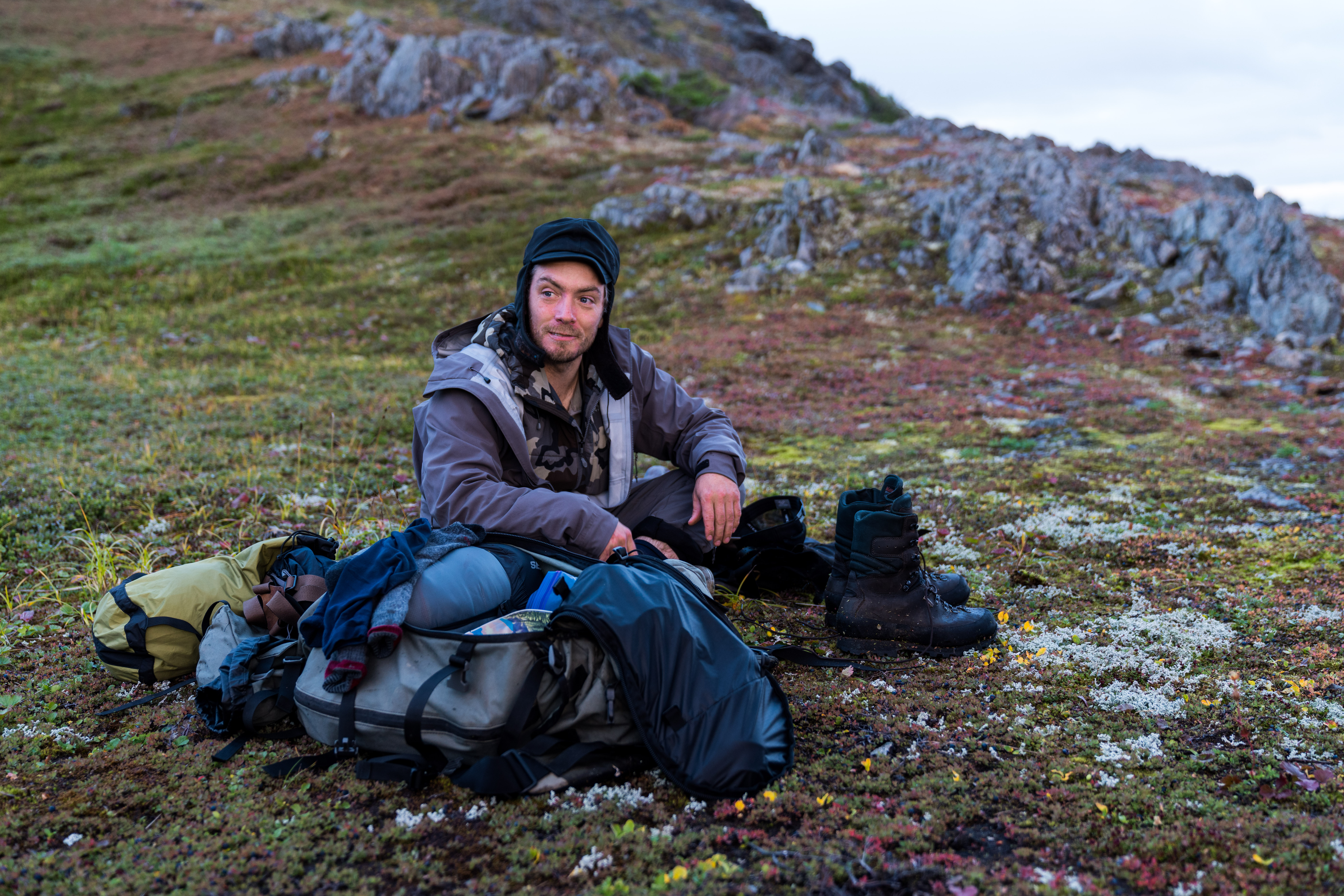 A mountain goat guide rests by his gear.