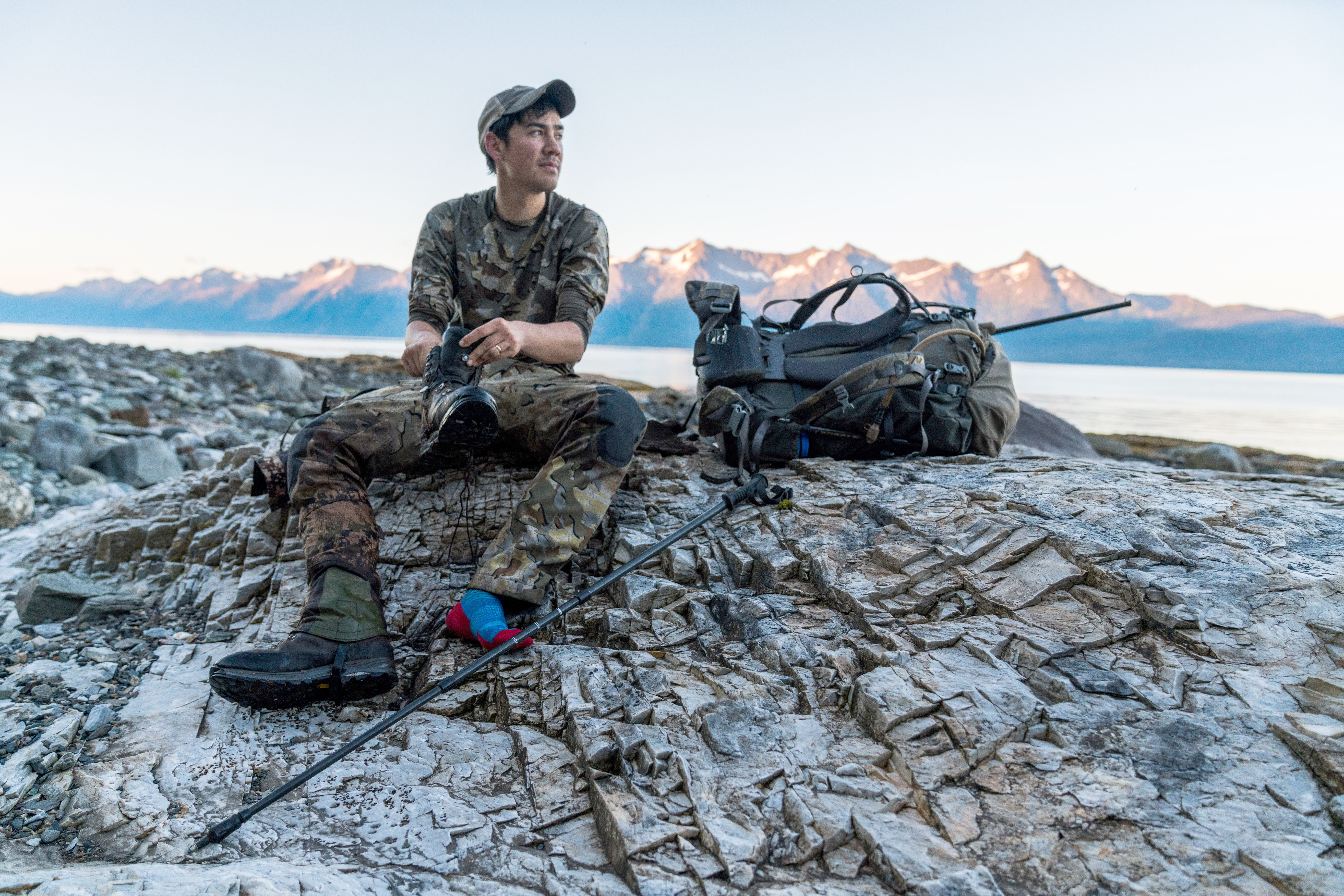 A mountain goat hunter empties rocks from his boot.