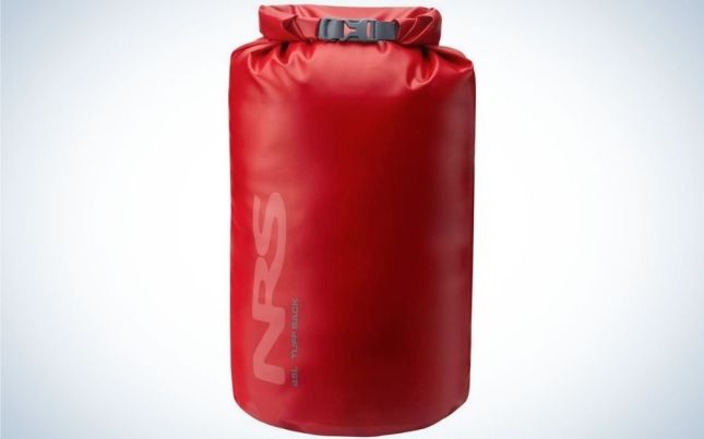 A large bag similar to a boxing bag which is red and in the shape of a cylinder.