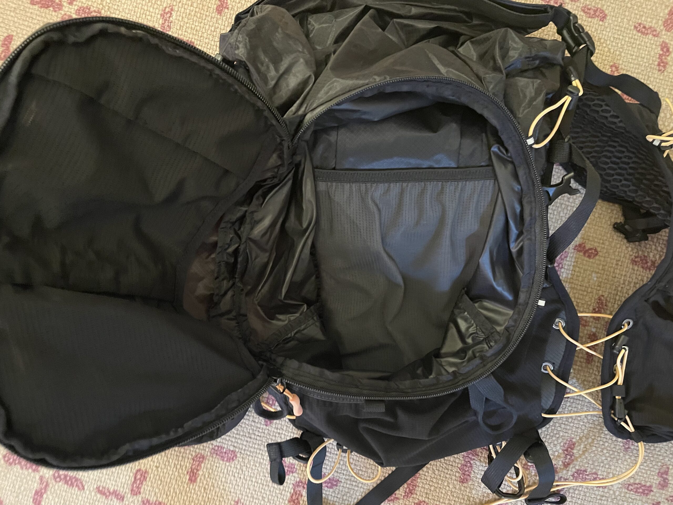 A black Deckers X Lab NVRSTP backpack with the front pocket open