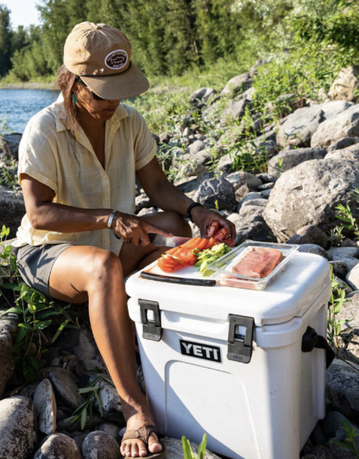 A woman preparing food on a white cooler