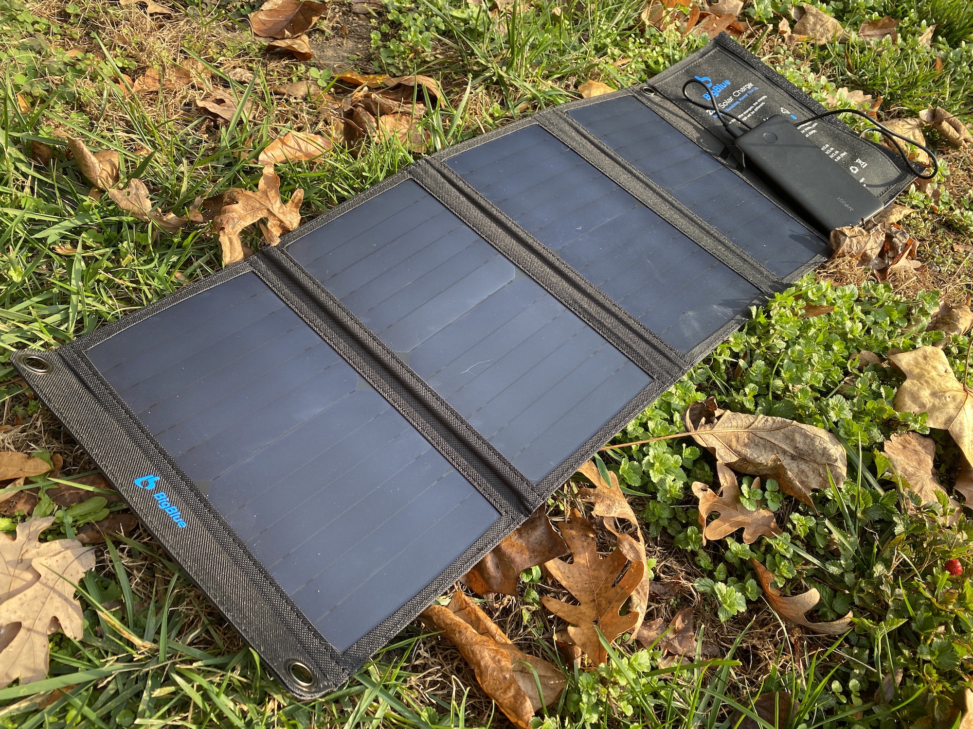 A solar charger in the grass charging a power bank