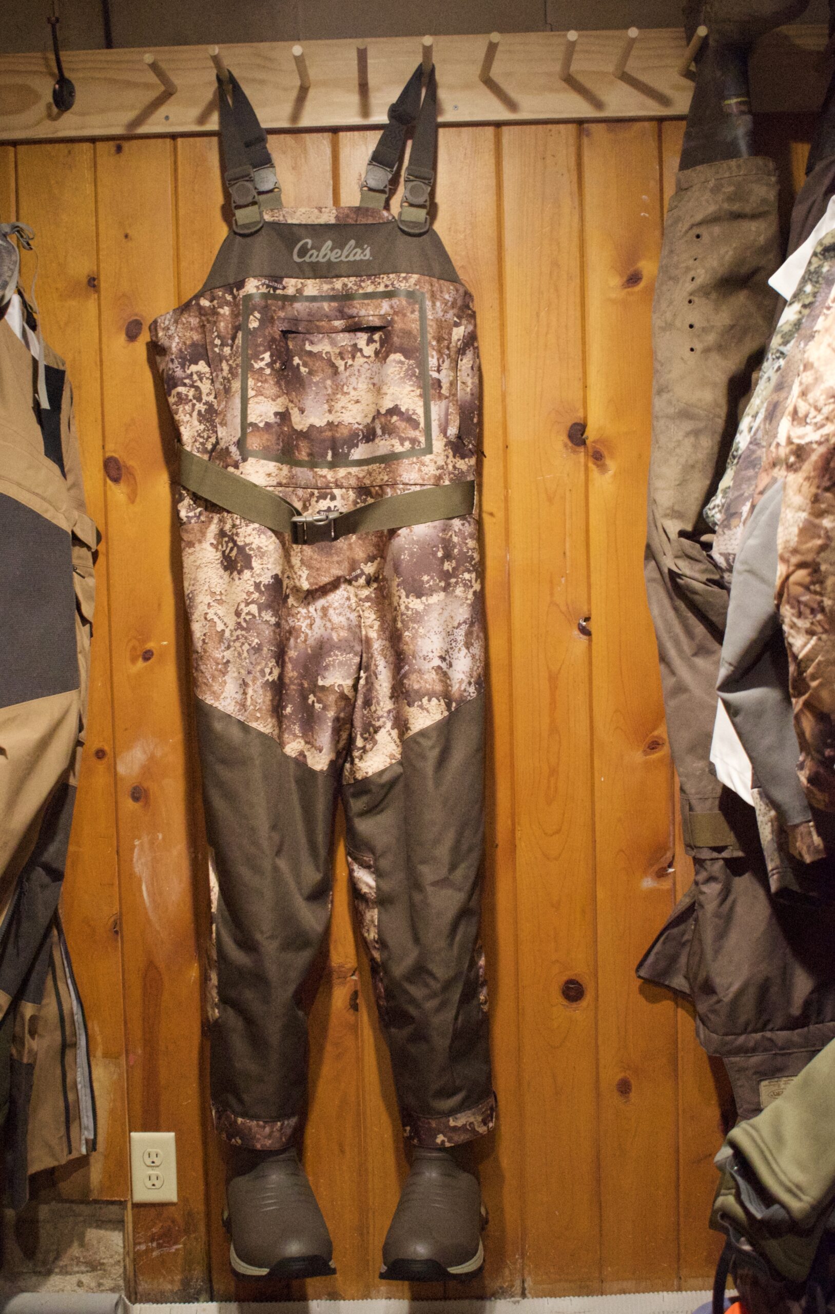 A pair of Cabela's waders hanging in a wood closet