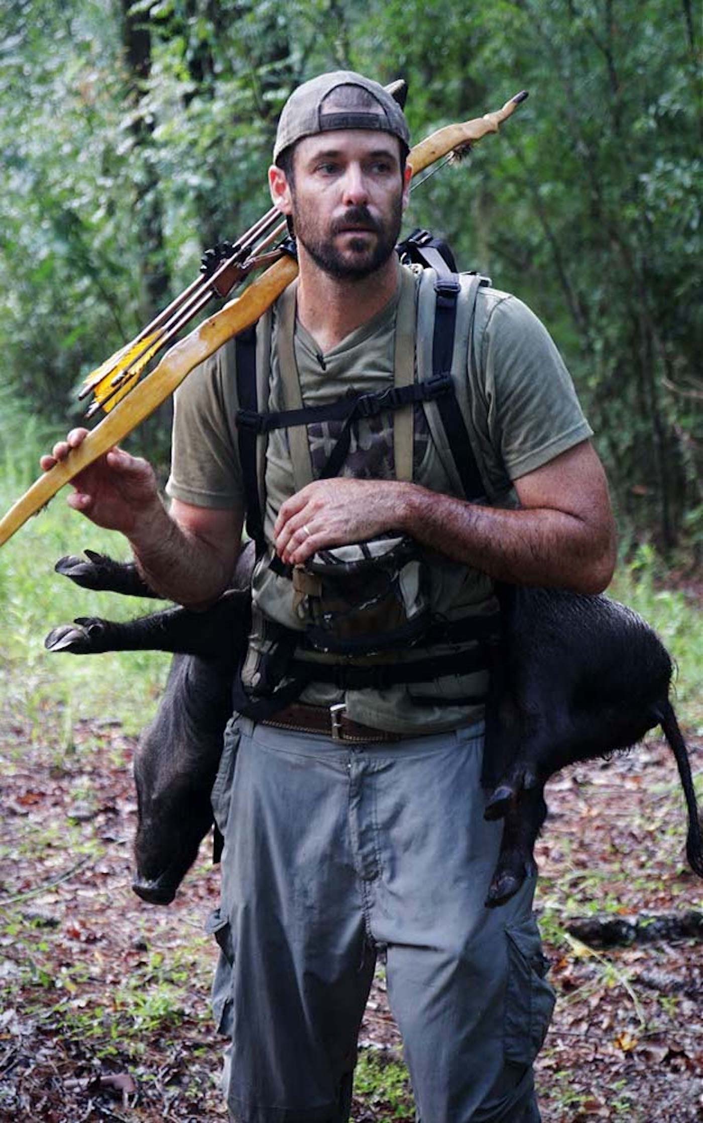 The author with a homemade bow hunting a pig