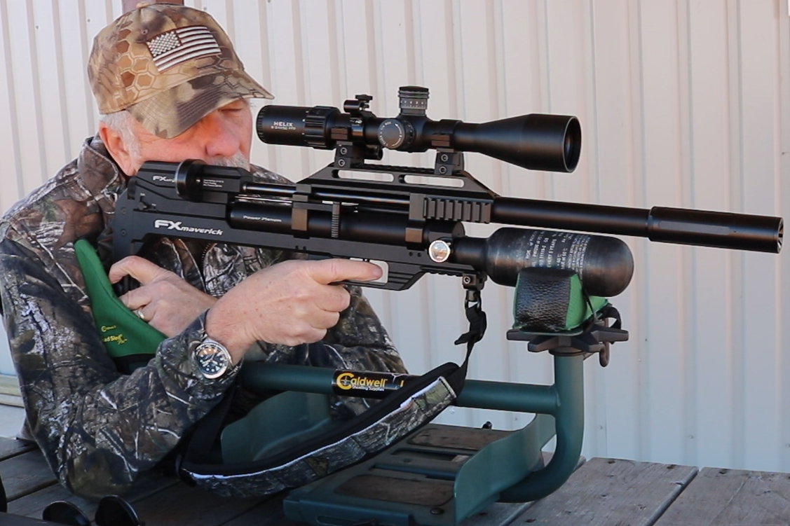A man shooting a black airgun looking through a black air rifle scoppe