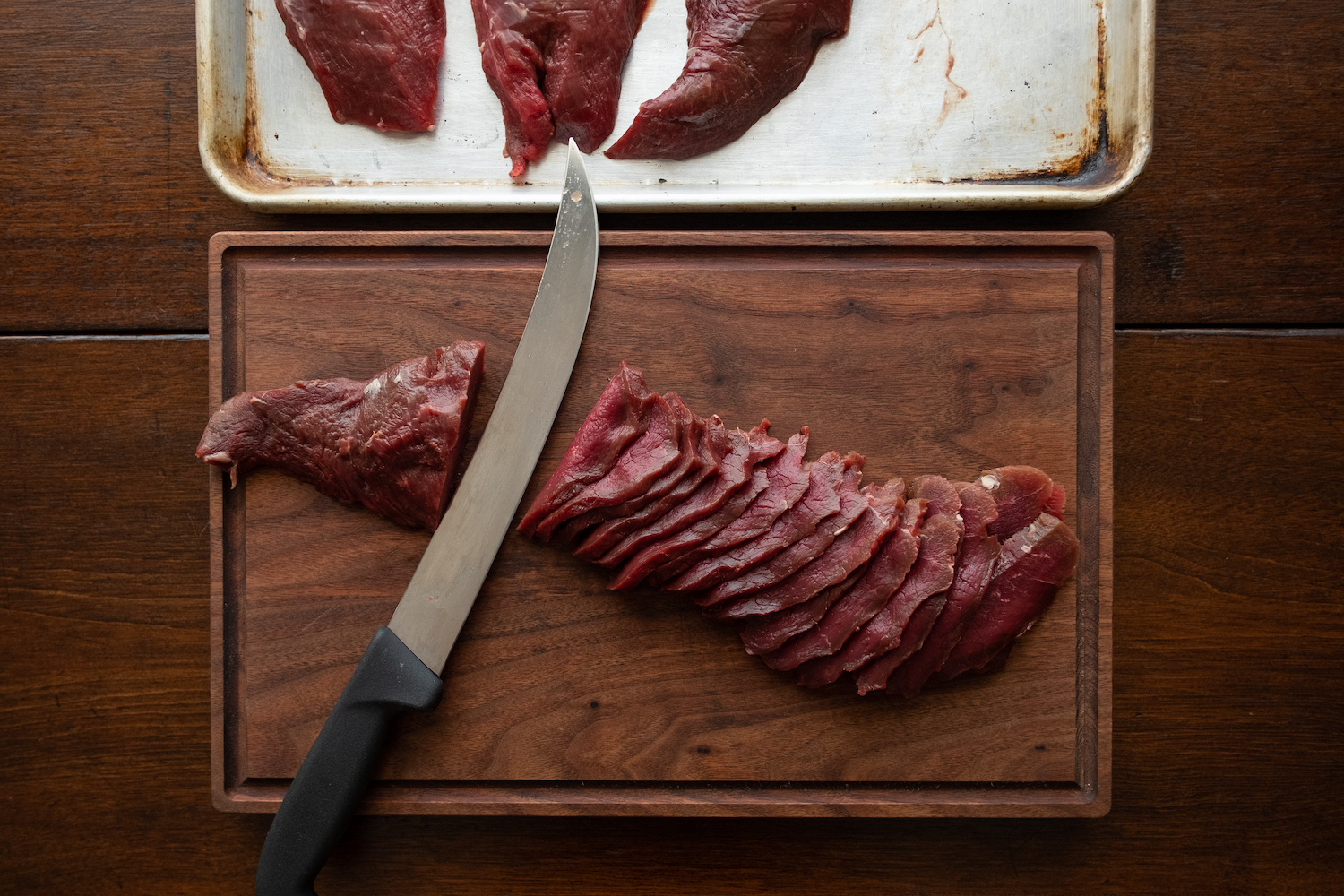 A wooden cutting board of raw meat