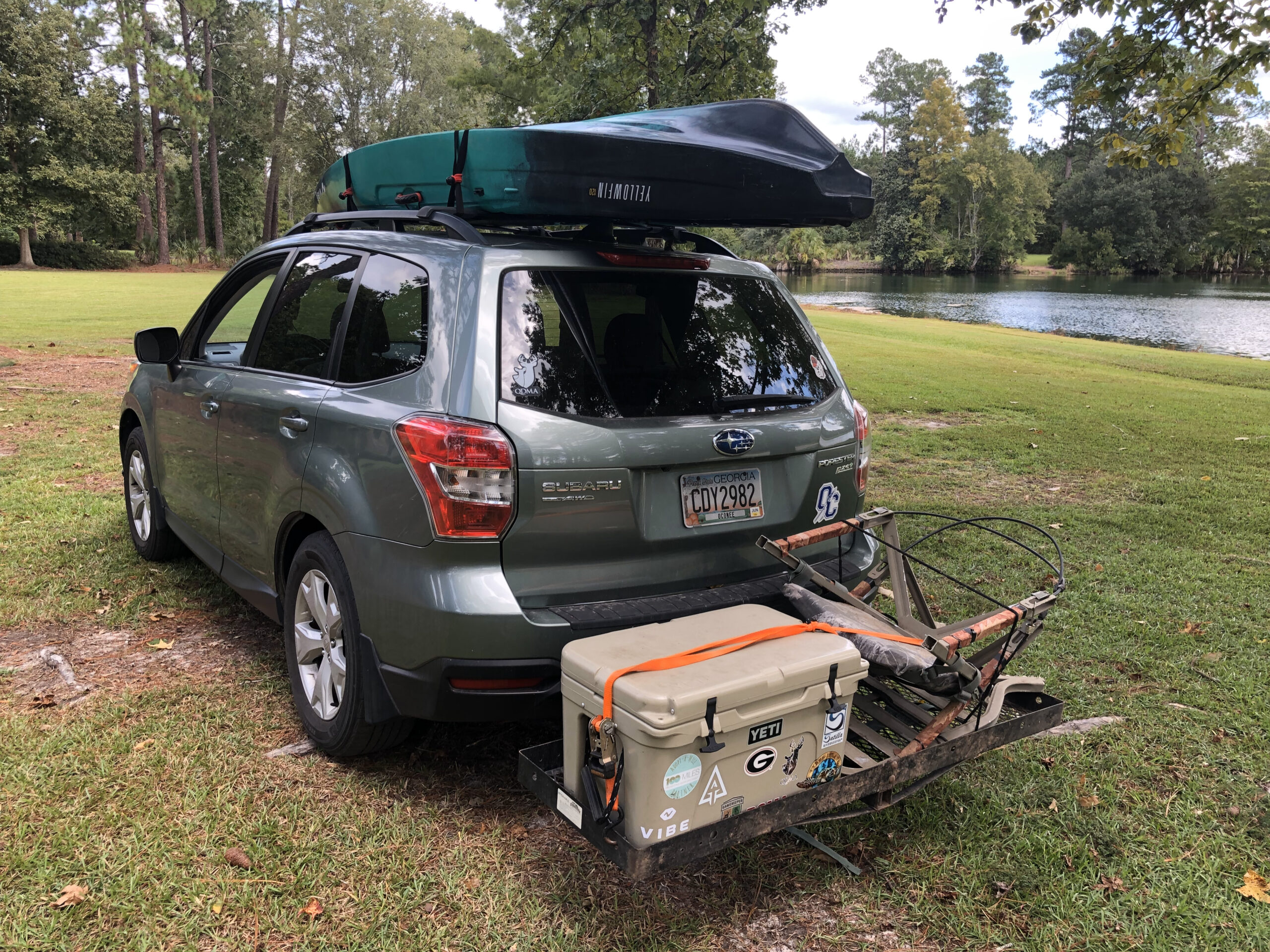 A Subaru Forester with a fishing kayak nad cooler.