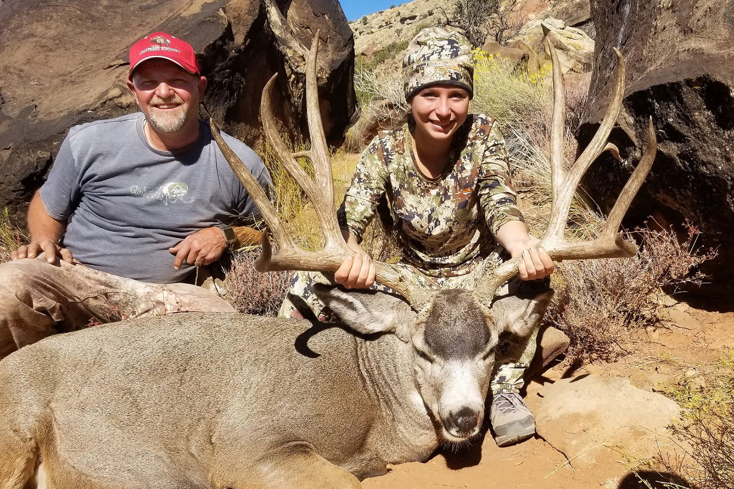 young hunter shows off mule deer