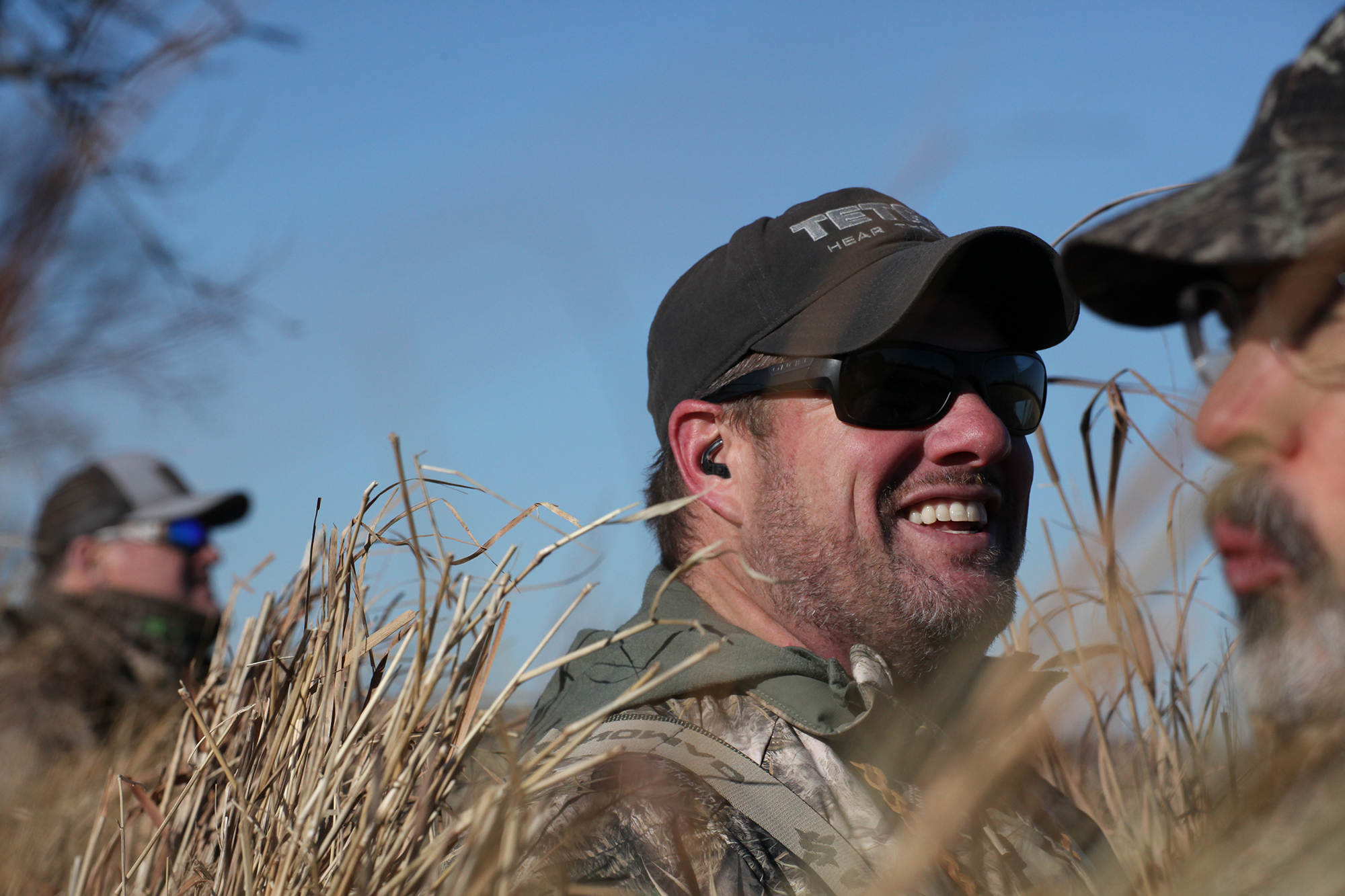 A hunter wears tetra hearing aids during a hunt
