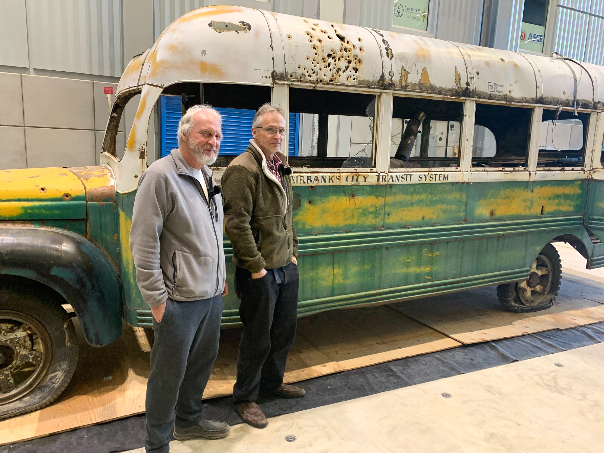 Two hunters stand beside Bus 142 at the University of Alaska Fairbanks.