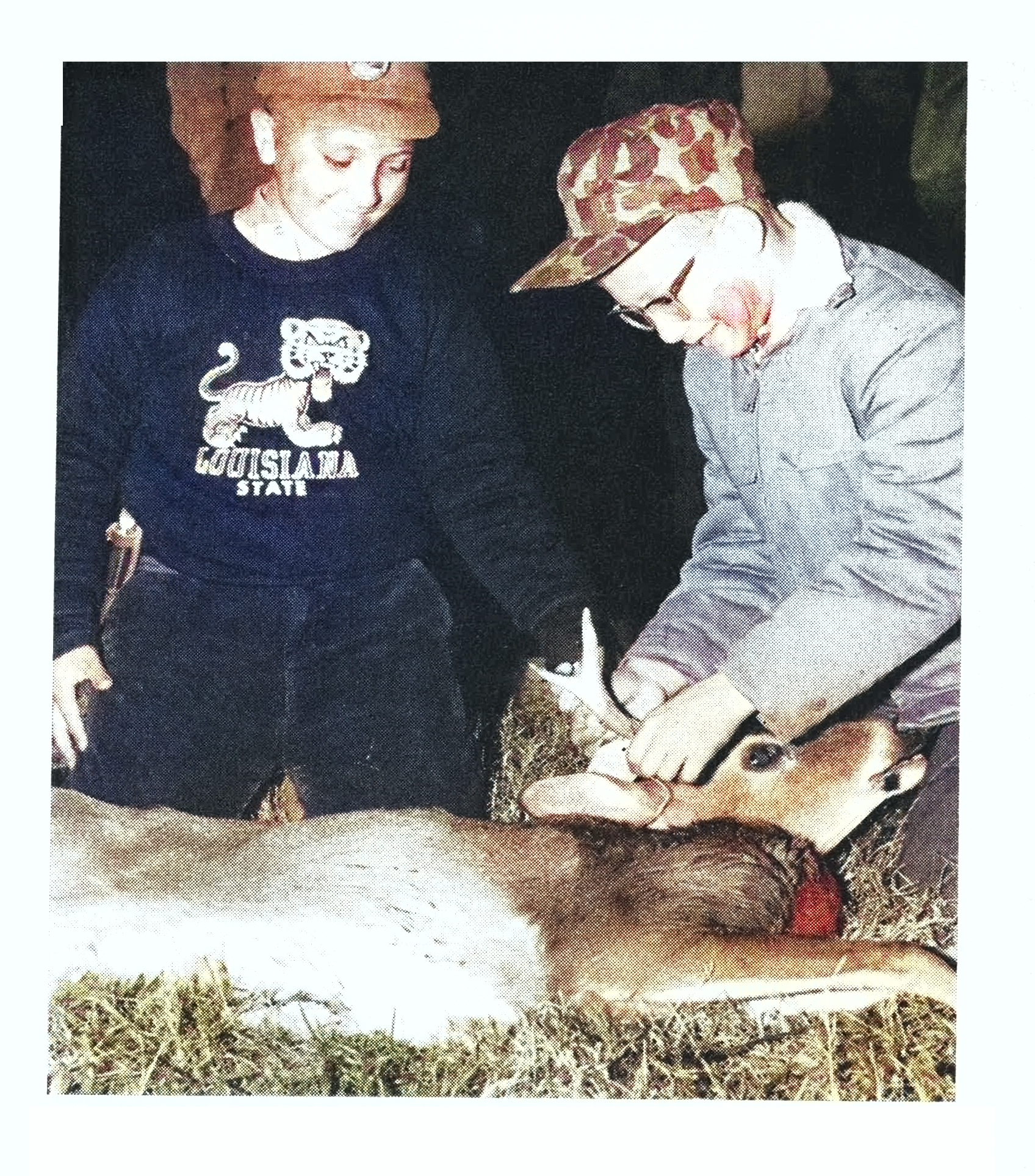 An old colorized photo of two young new deer hunters.