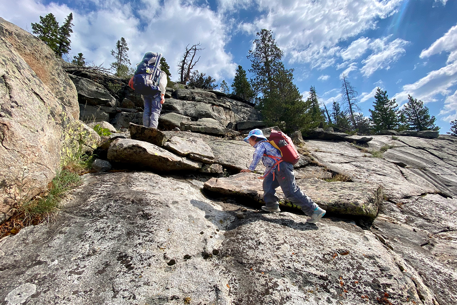 kid hiking up steep rock face