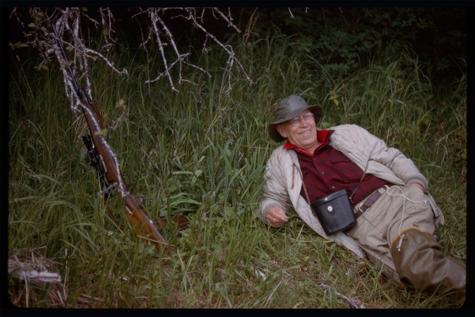 Jack O'Connor, reclining in the grass while taking a break on a hunt.