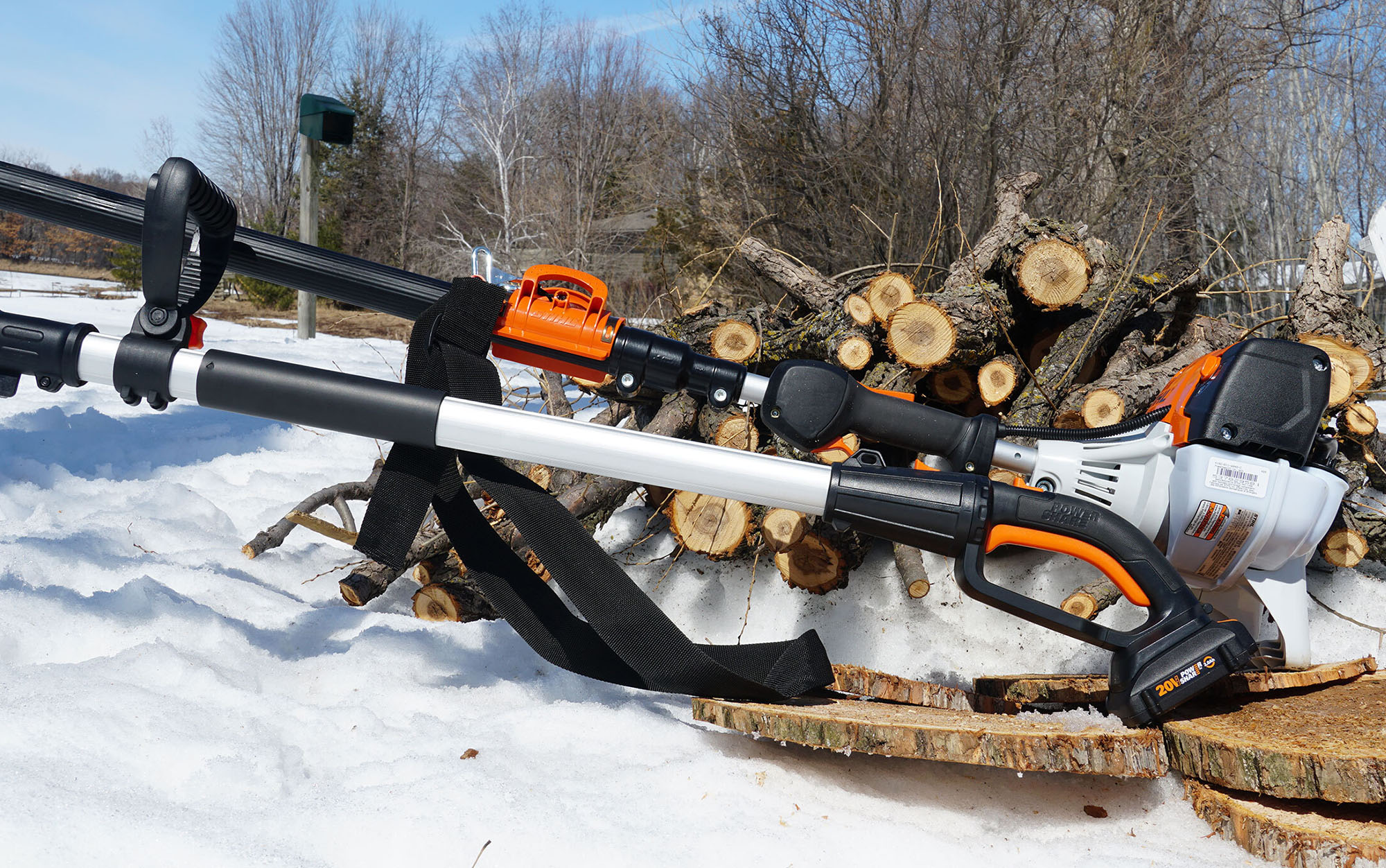 Two of the best pole saws sit next to wood.