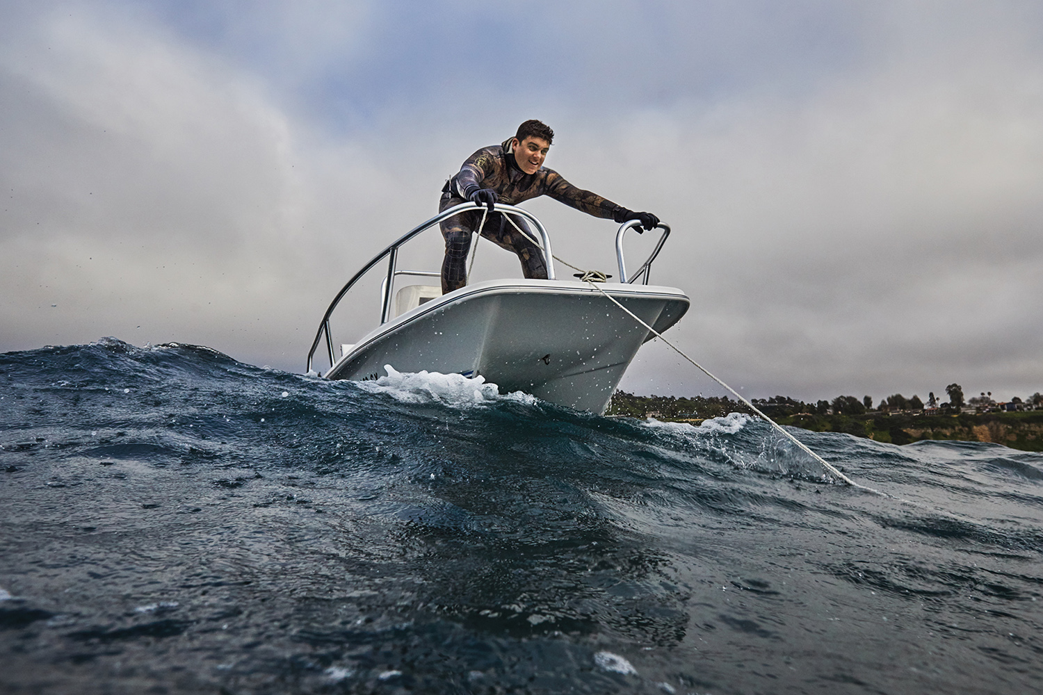 spearfisherman stands on deck of boat