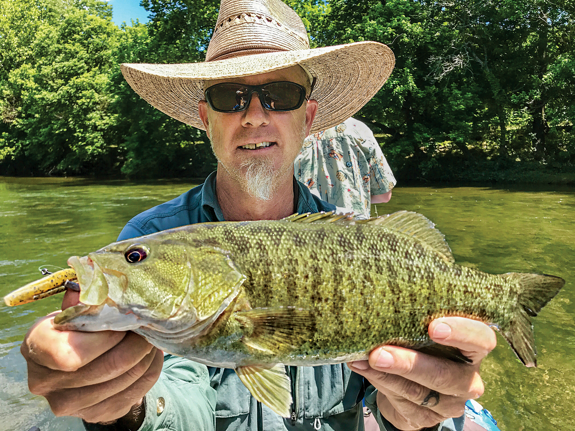 A fish bum holds up a smallmouth bass.
