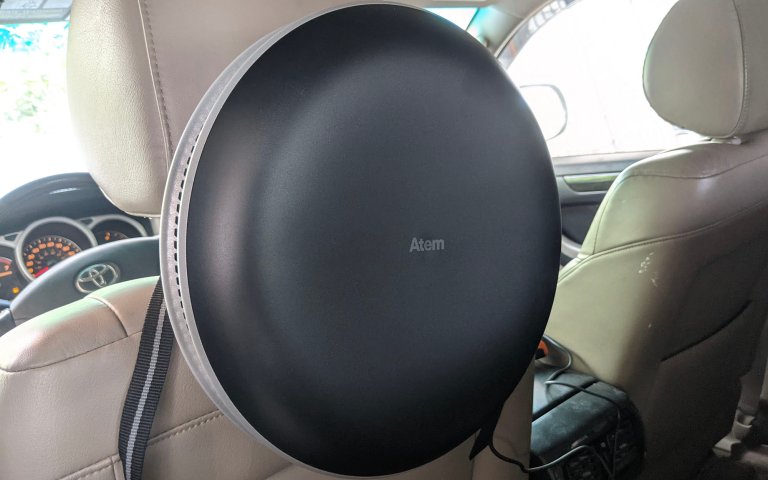 IQ Atem air purifier attached to the back of the driver's seat inside a Toyota 4runner