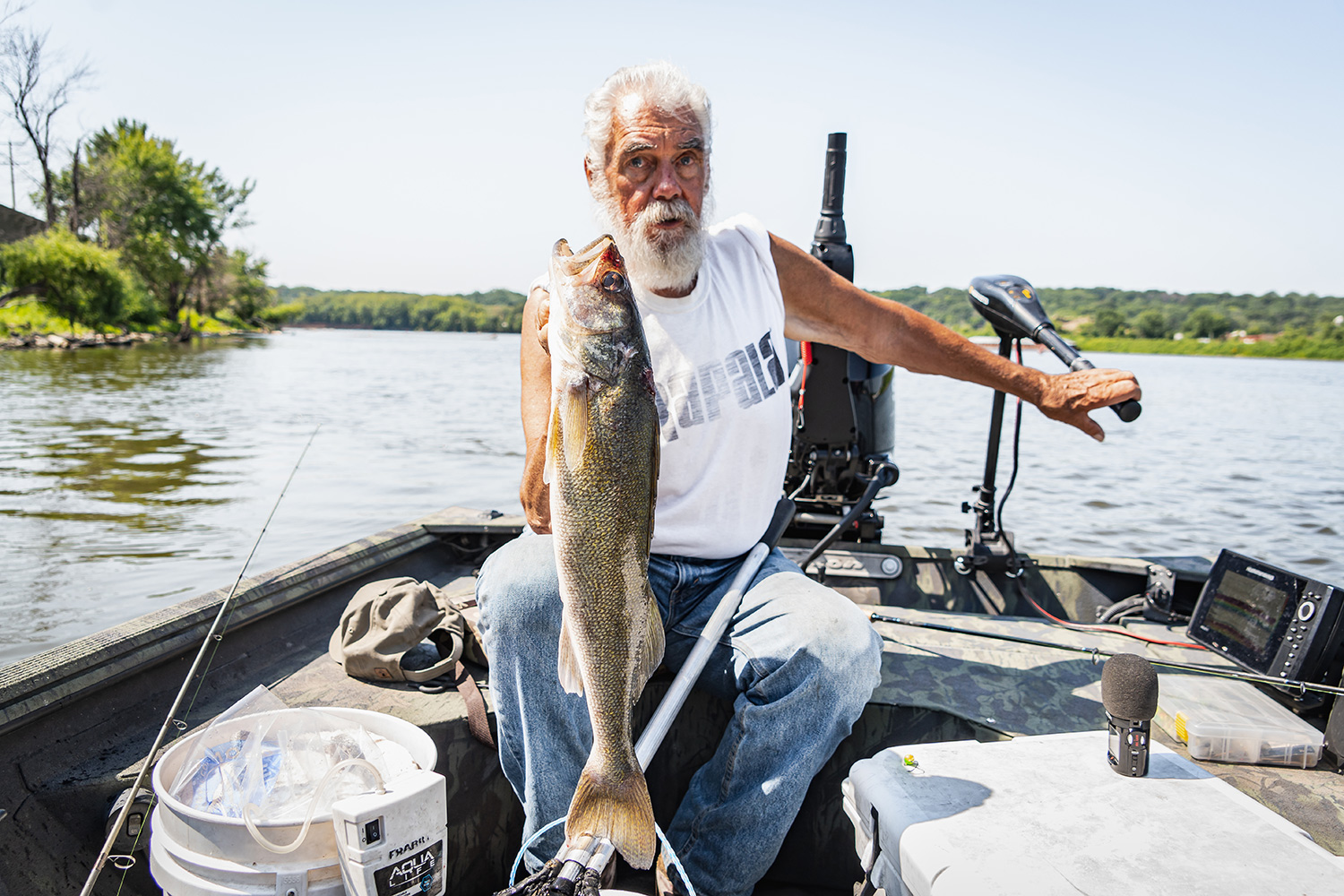 Dick Grzywinski, sitting in boat, holds up a large walleye