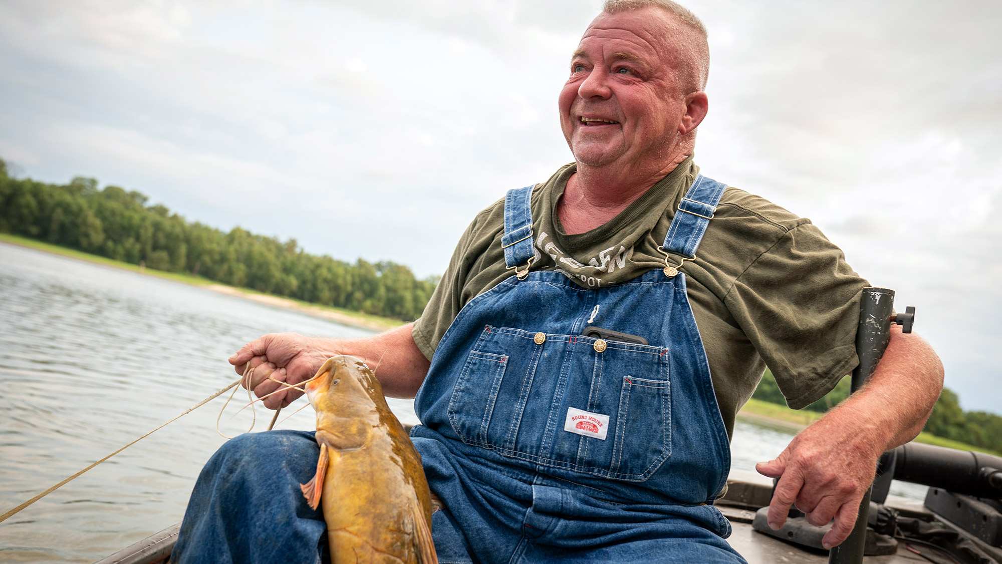 Trotliner holding a flathead catfish on his lap