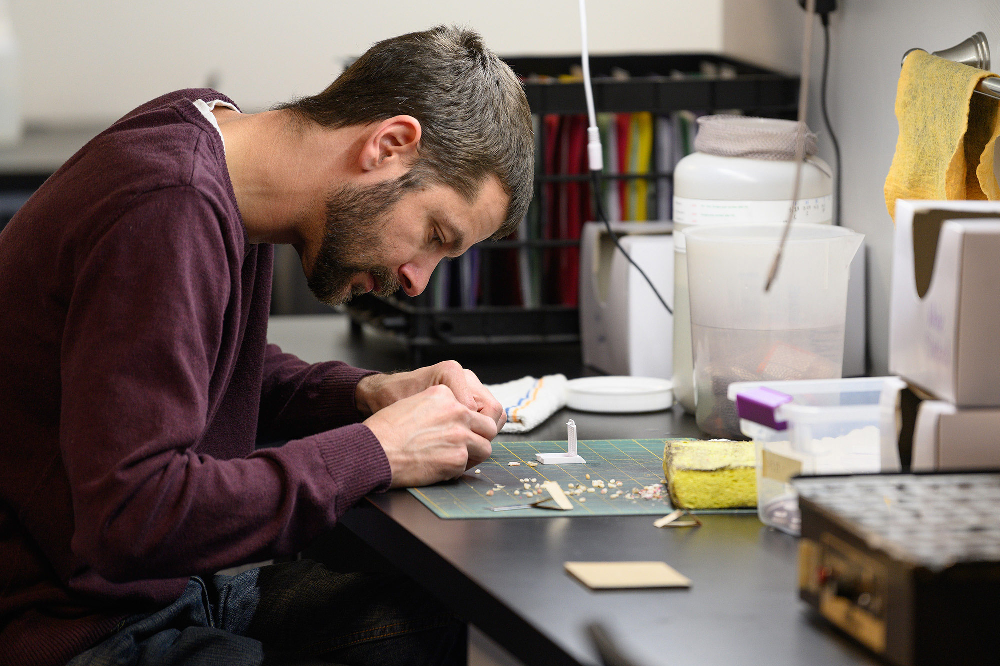 biologist AJ Stephens works with small sections of tooth at a desk