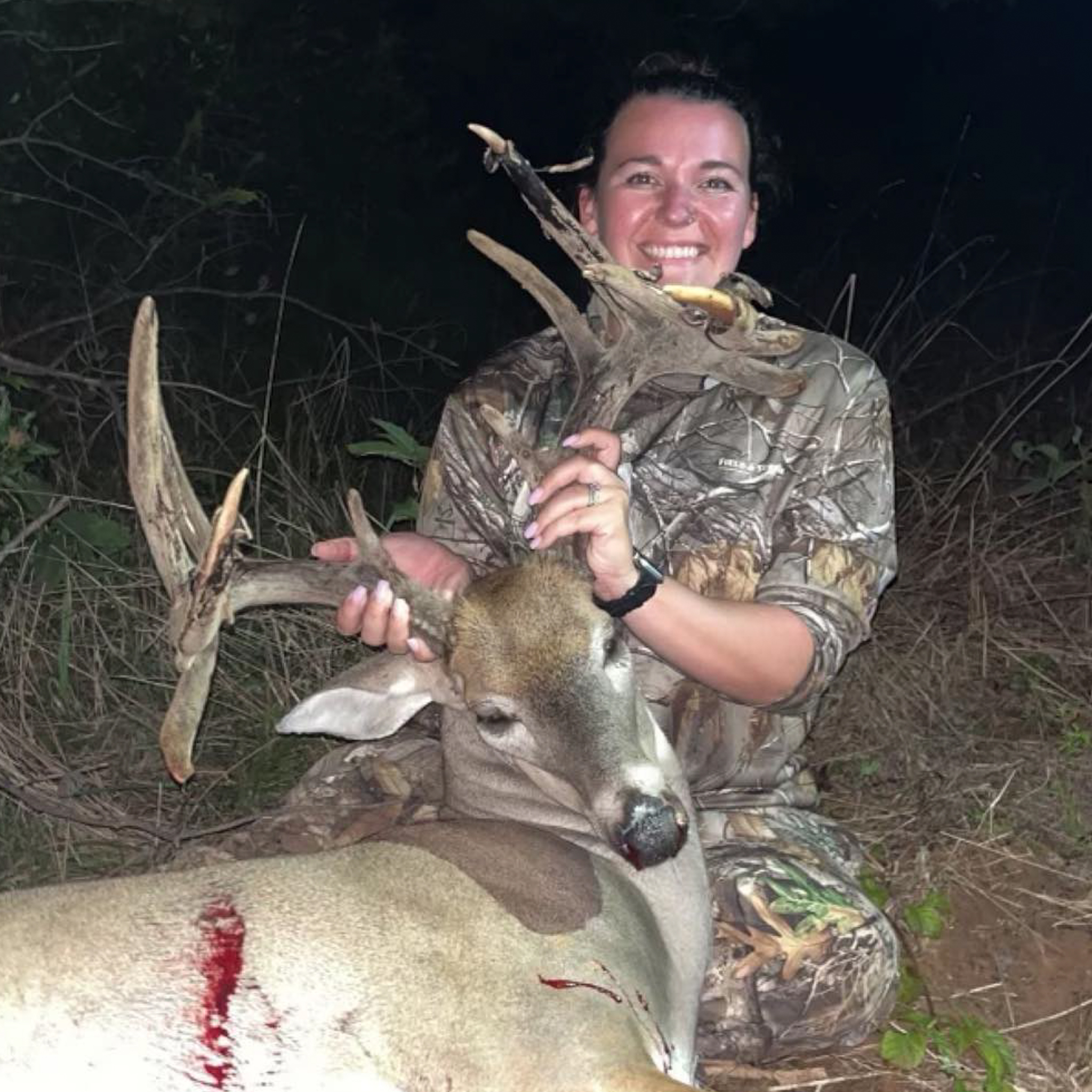 Kristina Causey smiling with a big buck.