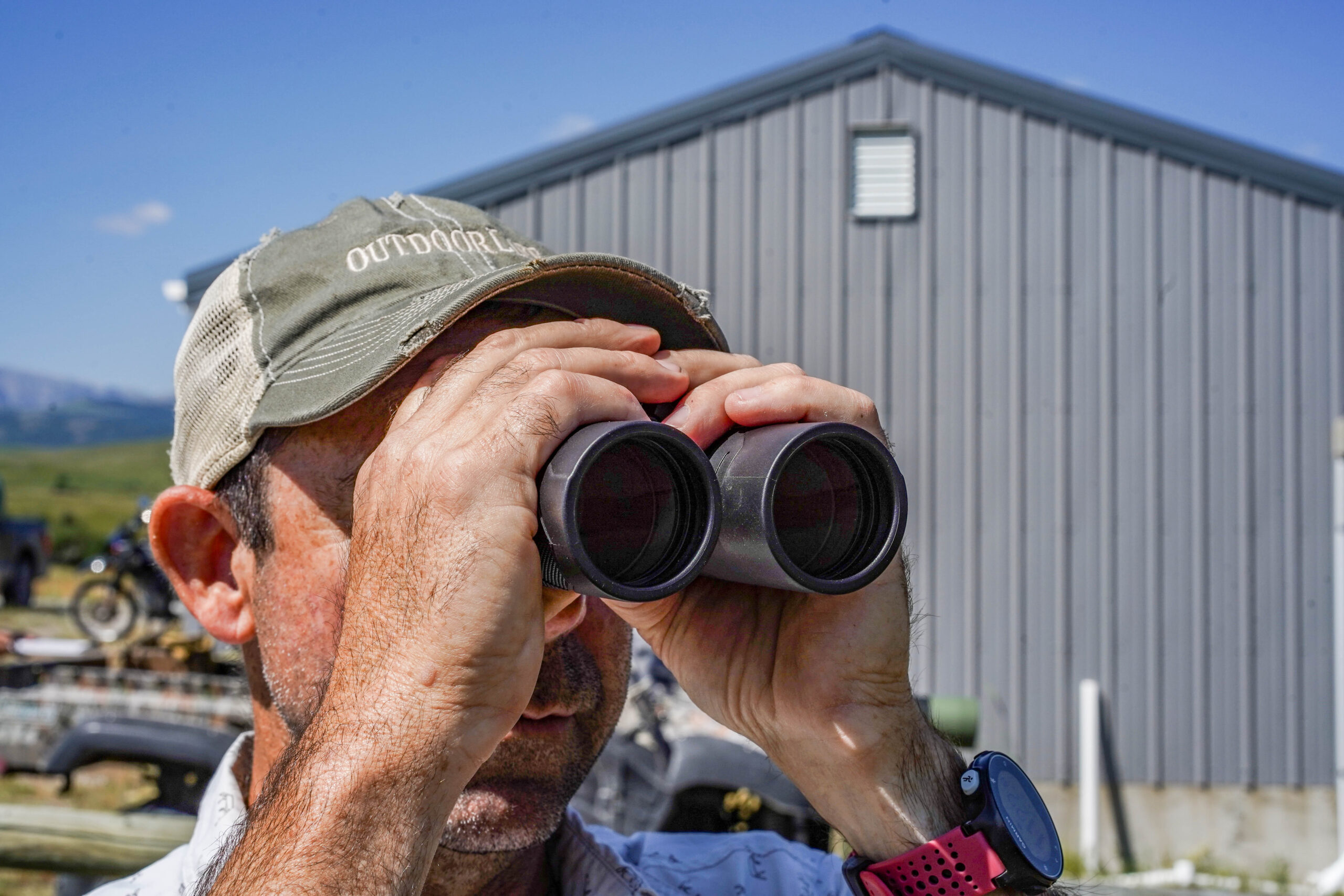 Man holds binoculars up.