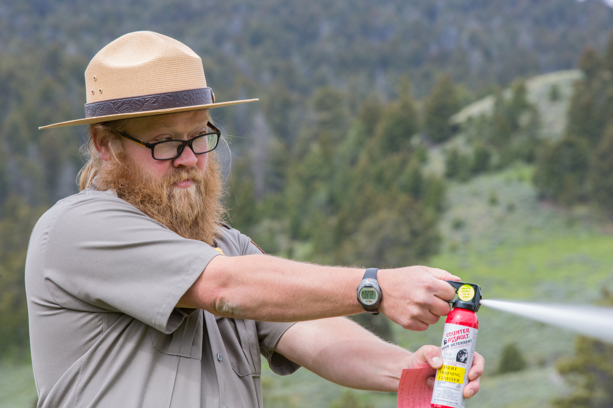 A National Park Service ranger deploys a can of bear spray.
