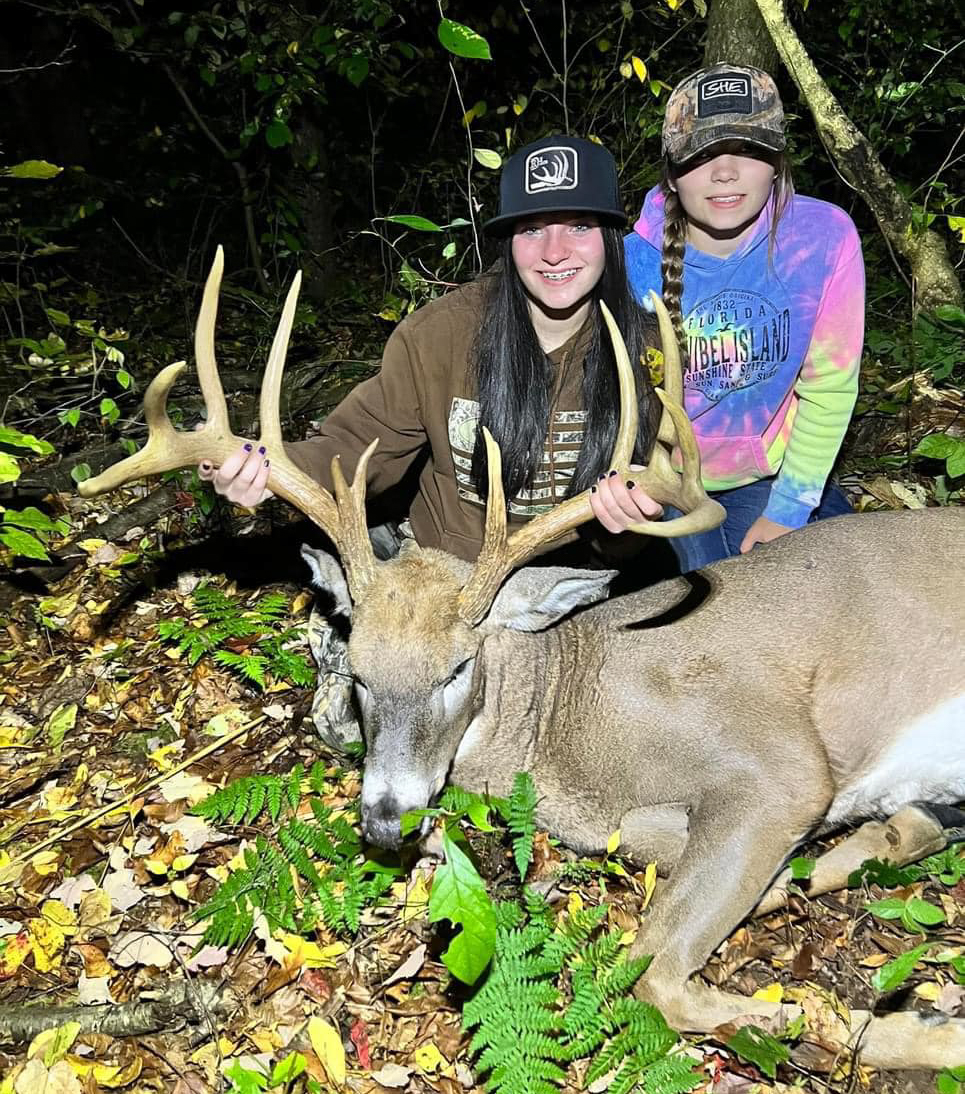 A teenage hunter and her sister with a nice buck.