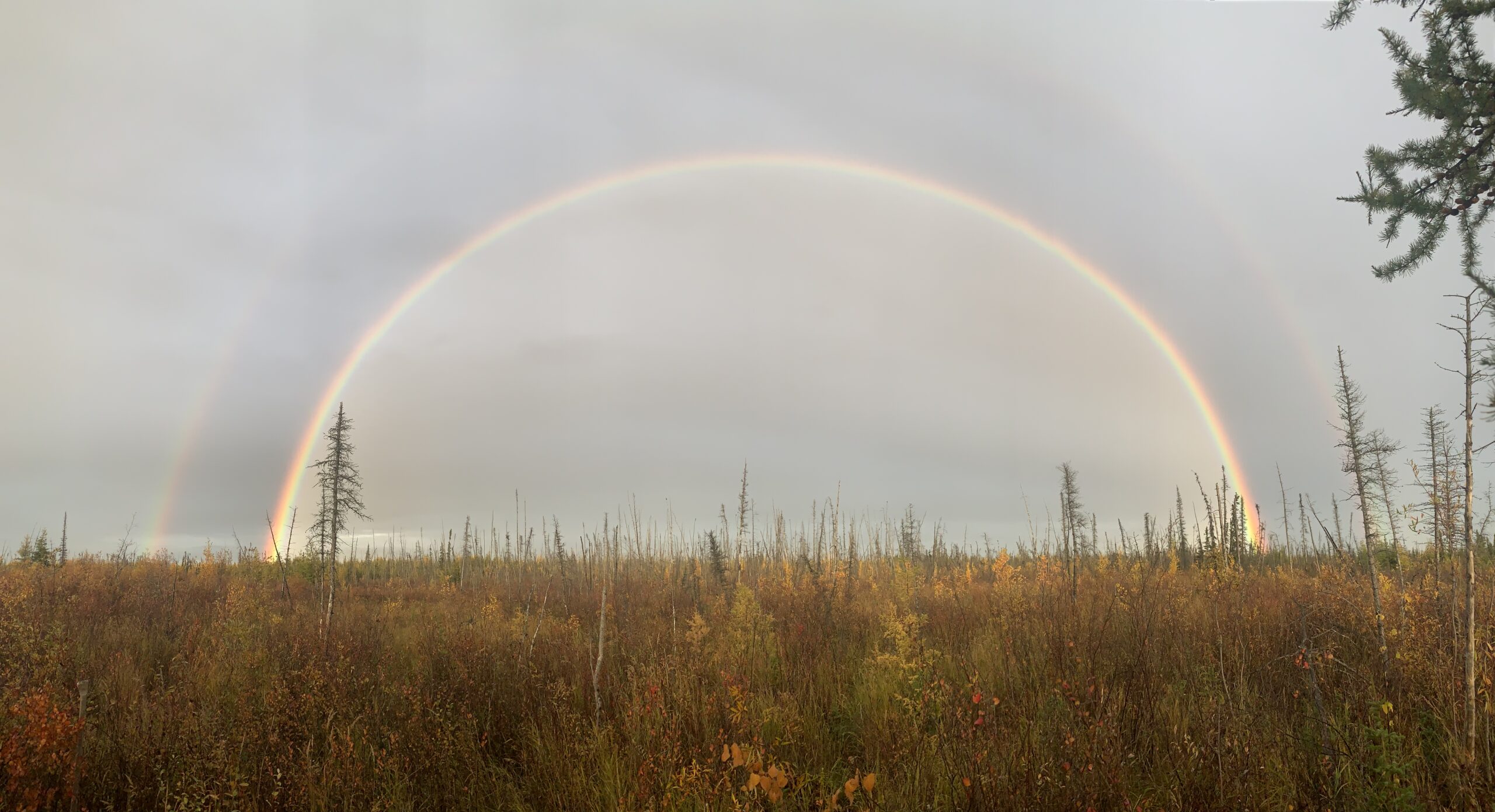 An evening rain shower leaves a double rainbow