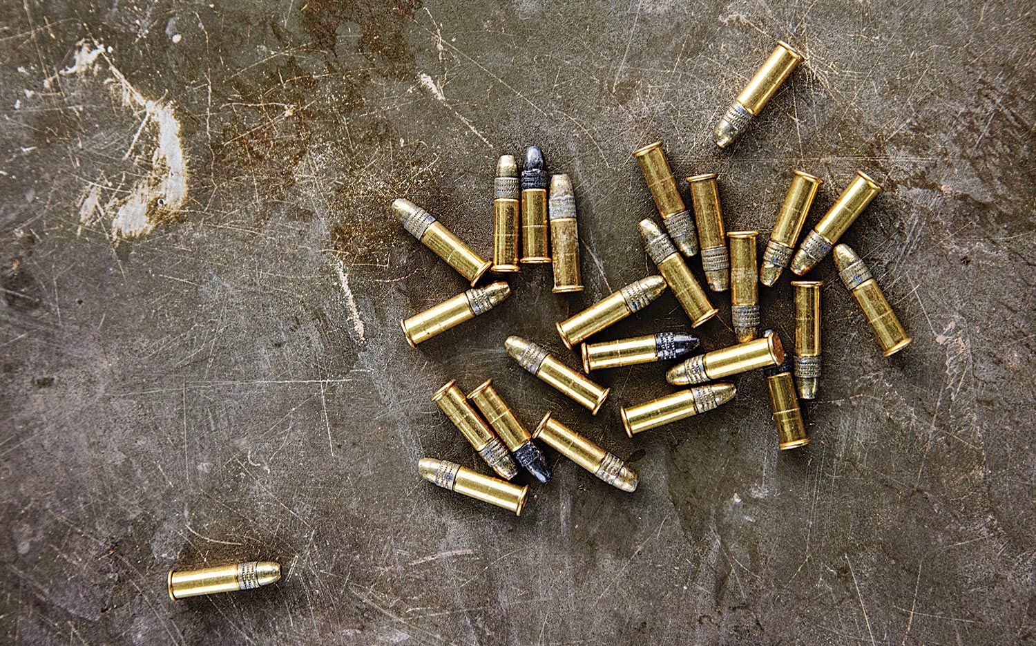 A collection of 22 LR cartridges on a stone background